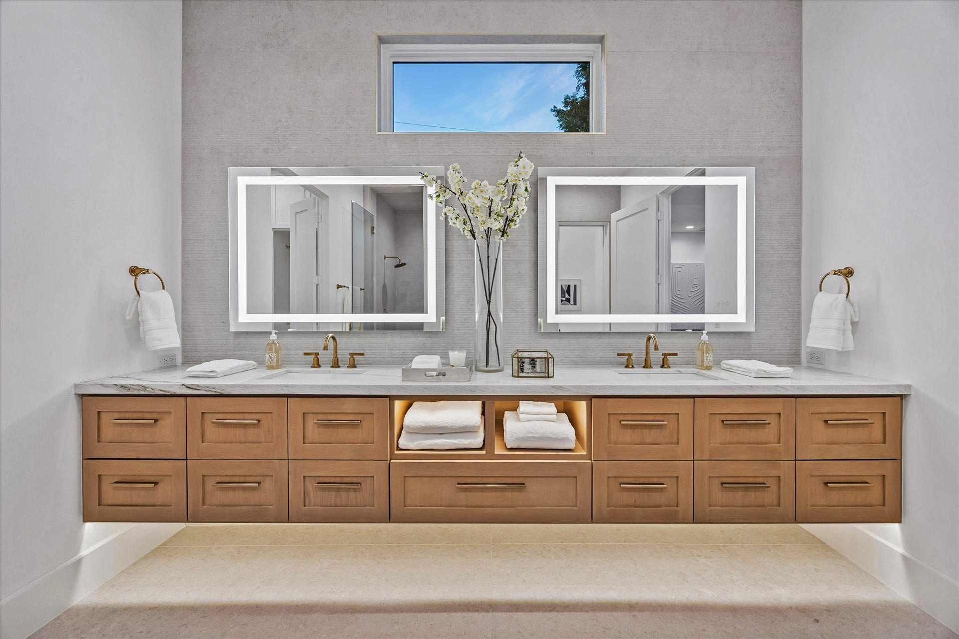 4230 Riley Street, Houston, TX 77005 Sleek primary bath has plenty of cabinet storage. Features quartzite counters, LED mirrors, and tiled wall.