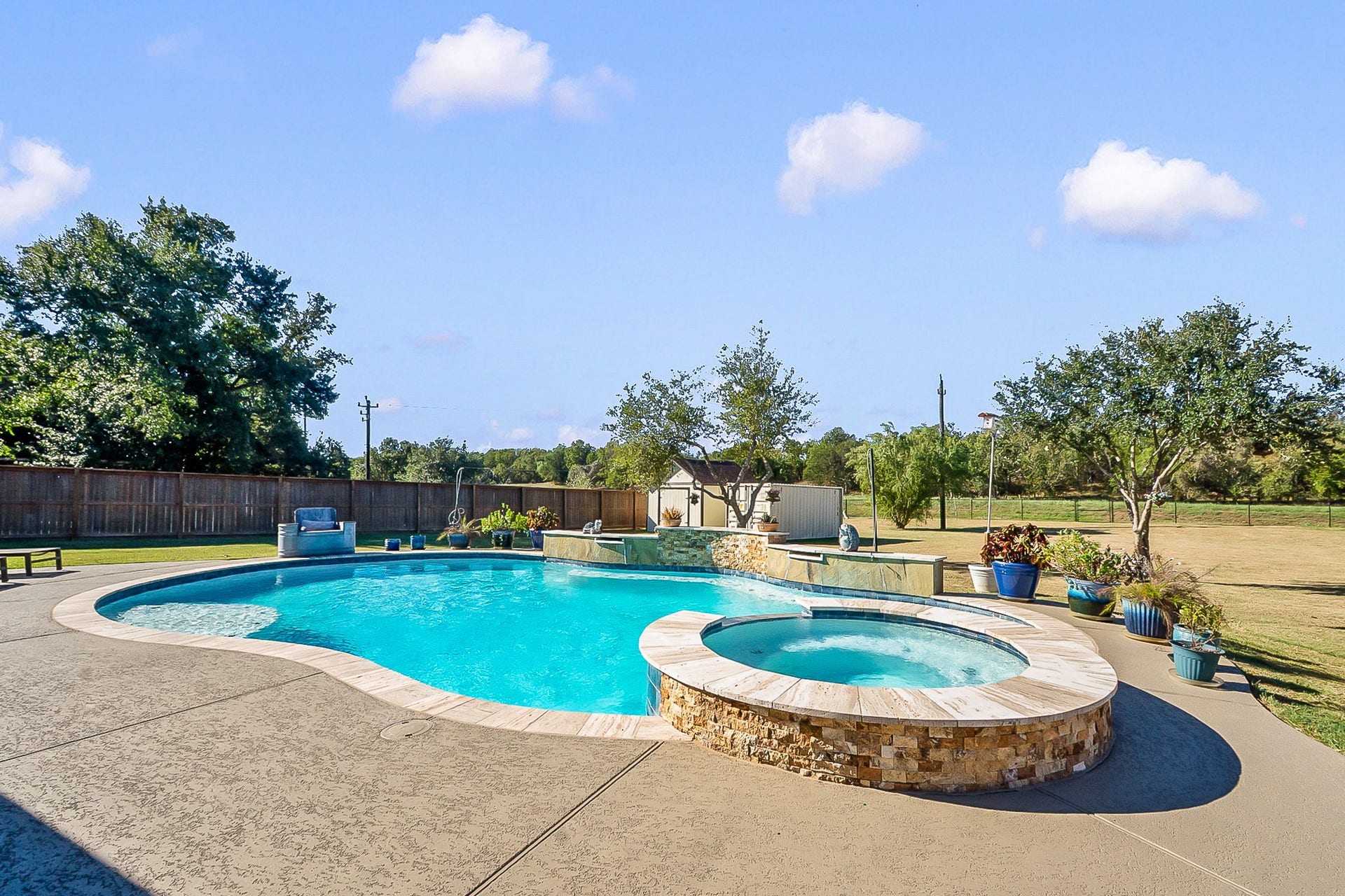 928 Oleander Street, Lake Jackson, TX 77566 Enjoy a serene backyard oasis featuring a sparkling pool and spa, surrounded by a spacious patio and lush landscaping, perfect for relaxation and entertaining.