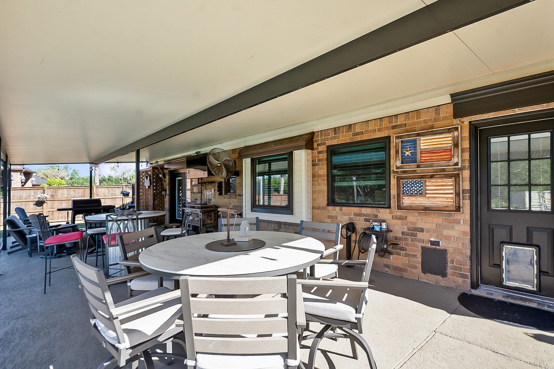 928 Oleander Street, Lake Jackson, TX 77566 Spacious 988 sq ft covered patio perfect for outdoor entertaining, featuring a dining area, cozy seating.