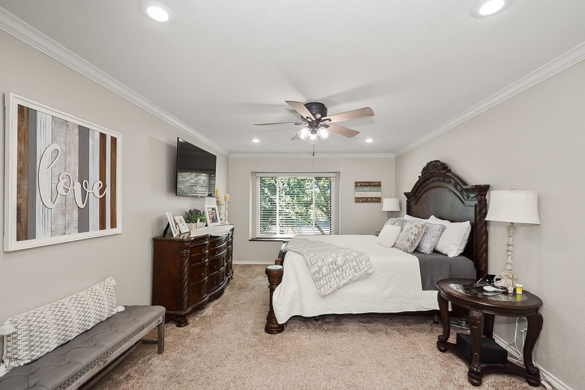 928 Oleander Street, Lake Jackson, TX 77566 Spacious Primary bedroom with elegant furnishings, featuring a large window for natural light, plush carpeting, and a cozy seating area.