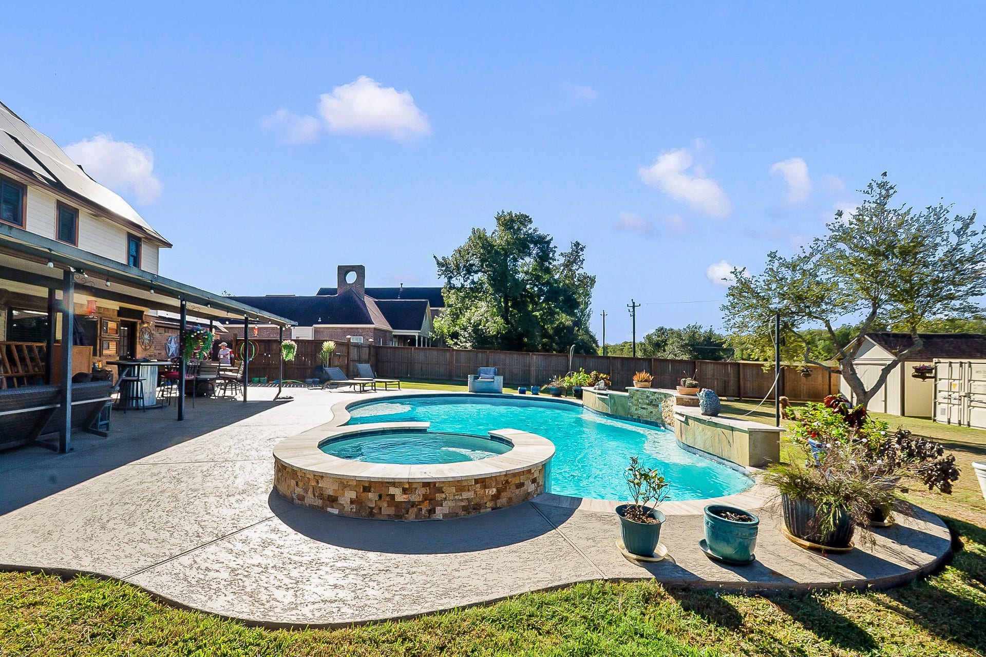 928 Oleander Street, Lake Jackson, TX 77566 Spacious backyard oasis featuring a luxurious 450 sq. ft. heated pool with a spa, ample patio space for entertaining, and lush landscaping for privacy and relaxation.
