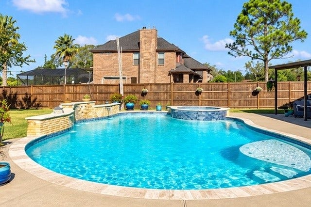 928 Oleander Street, Lake Jackson, TX 77566 Dive into luxury with this stunning backyard oasis featuring a sparkling pool, relaxing hot tub, and elegant stone accents, perfect for entertaining and enjoying sunny days.