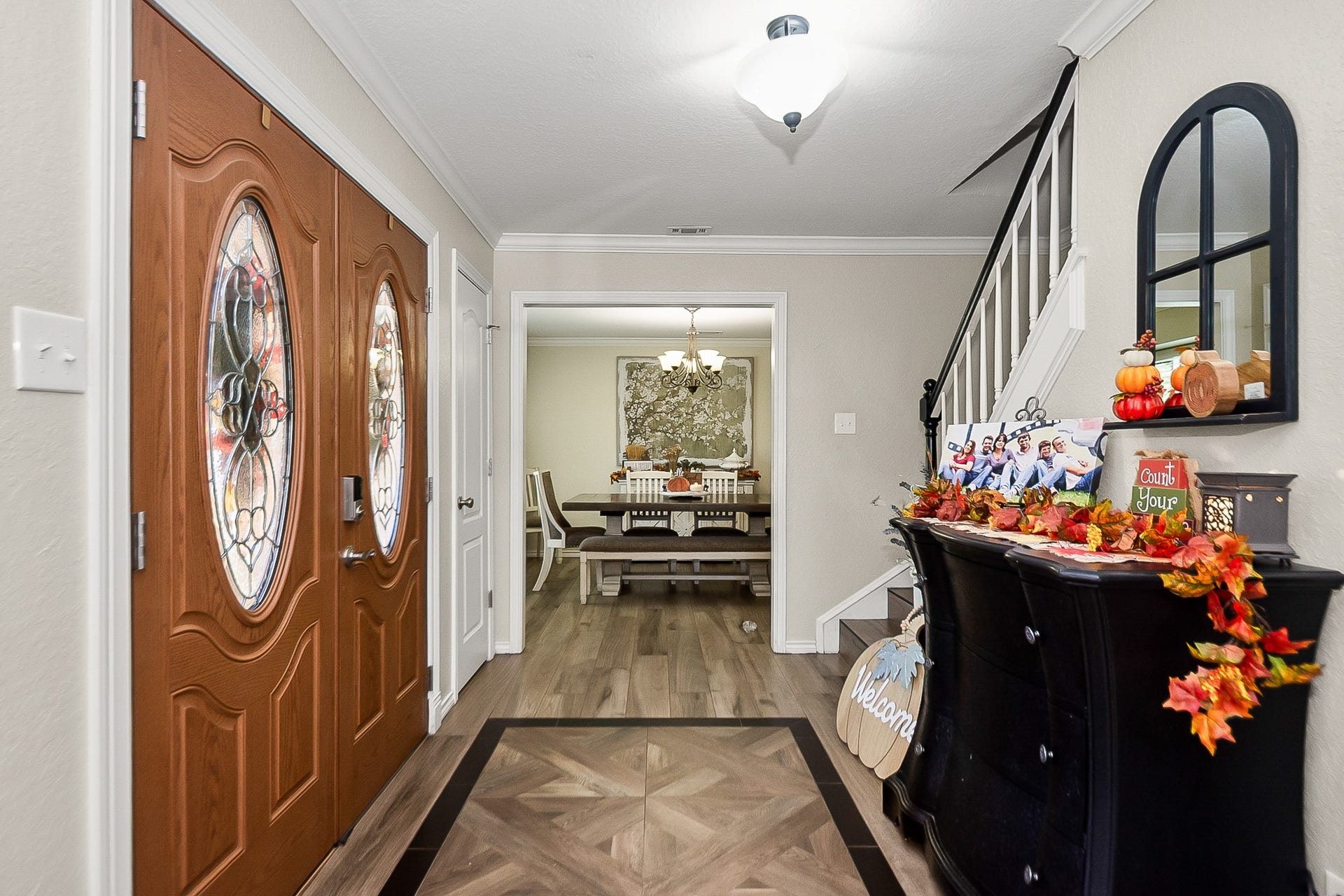 928 Oleander Street, Lake Jackson, TX 77566 Elegant entryway featuring double doors with decorative glass, leading to a cozy dining area. The space is accentuated by warm wood look flooring.