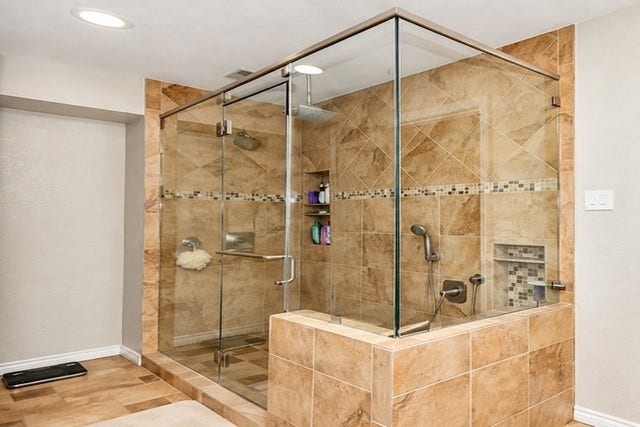 928 Oleander Street, Lake Jackson, TX 77566 Luxurious glass-enclosed shower with elegant tilework and modern fixtures, offering a spacious and stylish bathing experience.