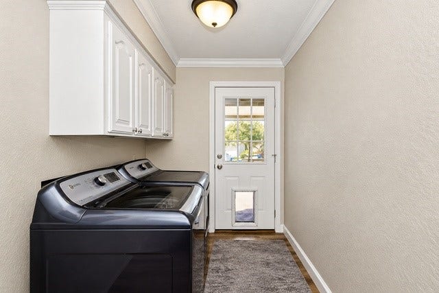 928 Oleander Street, Lake Jackson, TX 77566 Bright and functional laundry room featuring modern appliances, ample cabinet storage, and a convenient exterior door with a pet access panel.