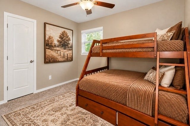 928 Oleander Street, Lake Jackson, TX 77566 Cozy 4th bedroom featuring a wooden bunk bed with storage, warm brown tones, and a stylish ceiling fan, creating an inviting retreat.