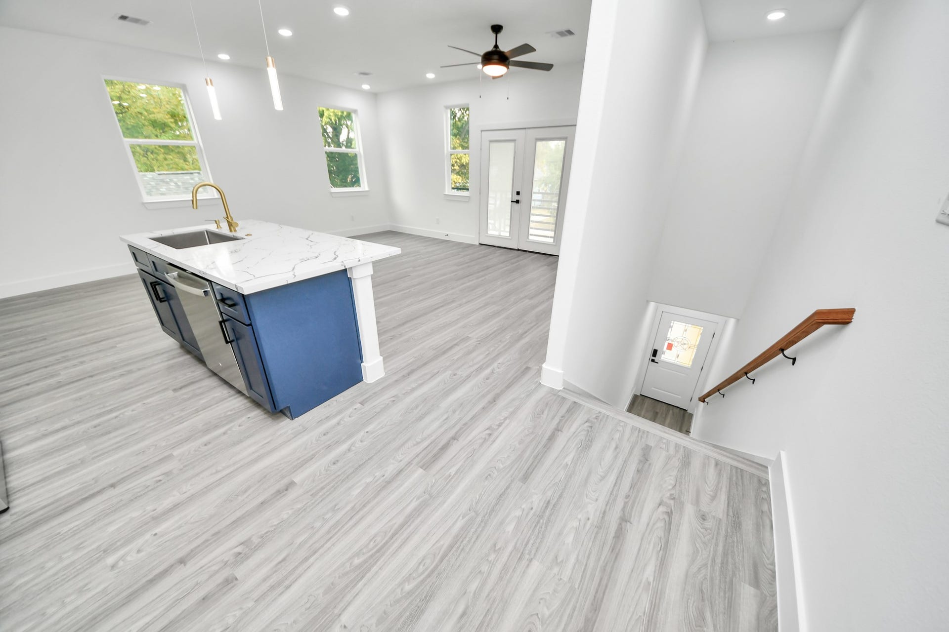 6707 Knox Street, Houston, TX 77091 Bright and spacious open-concept living area featuring modern gray flooring, a sleek kitchen island with a marble countertop, and large windows for natural light.