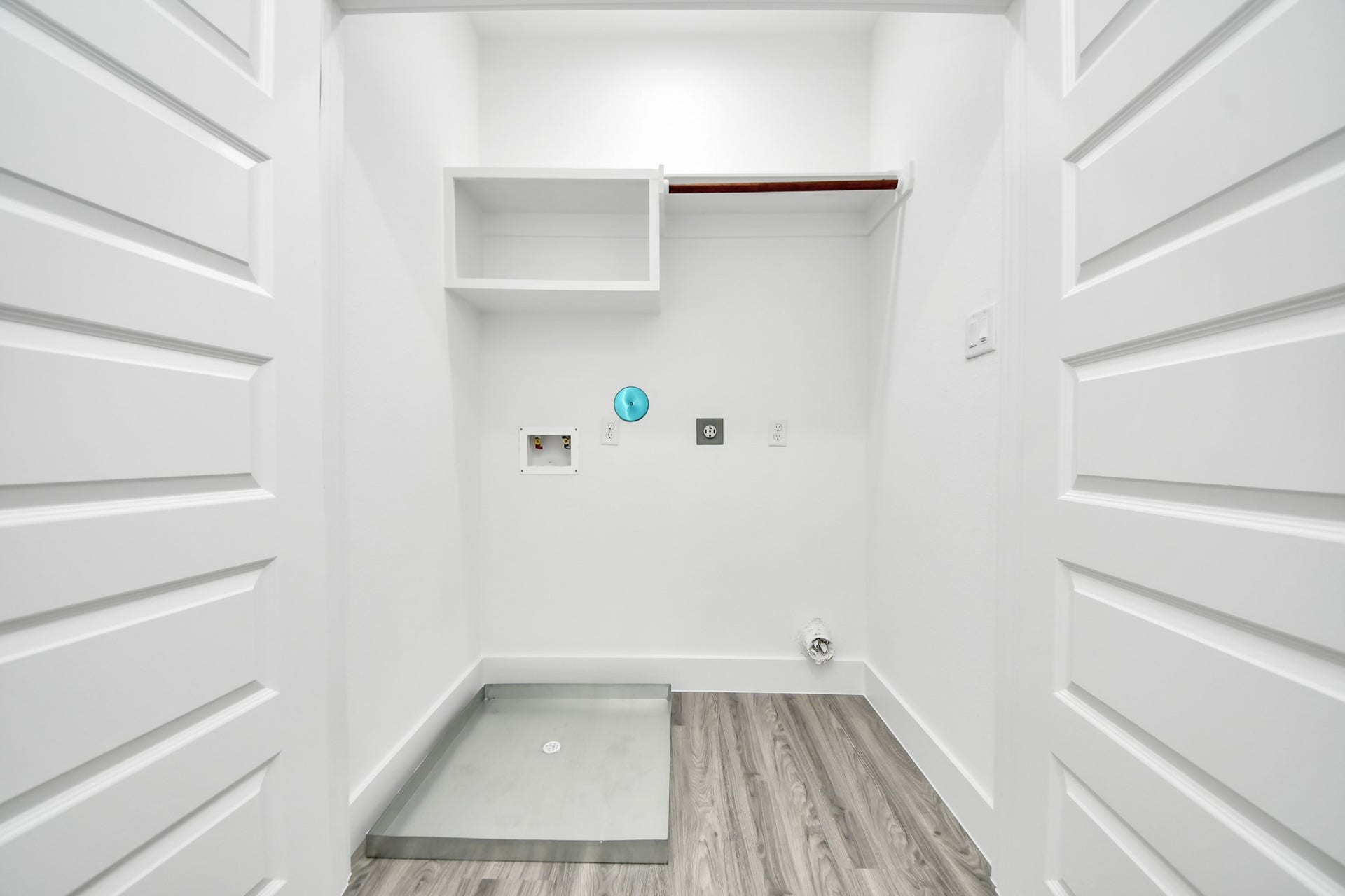 6707 Knox Street, Houston, TX 77091 Bright and functional laundry room featuring hookups for appliances, a convenient shelf for storage, and modern laminate flooring.