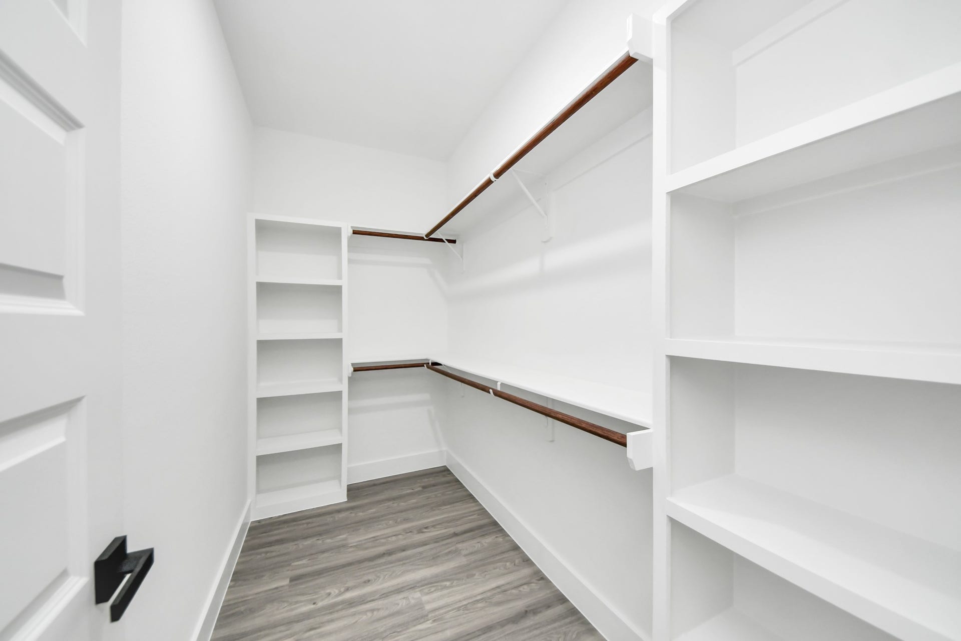 6707 Knox Street, Houston, TX 77091 Spacious walk-in closet with ample shelving and hanging space, complemented by sleek wood flooring for a modern touch.