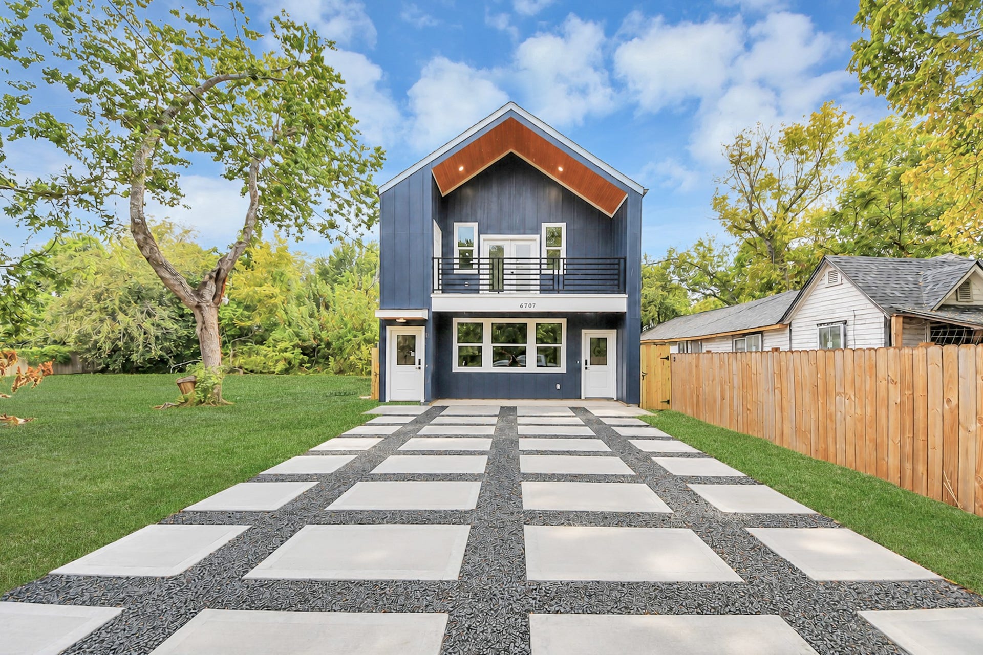 6707 Knox Street, Houston, TX 77091 Modern two-story home with a striking facade, spacious balcony, and sleek geometric driveway, set amidst lush greenery for a serene living experience.