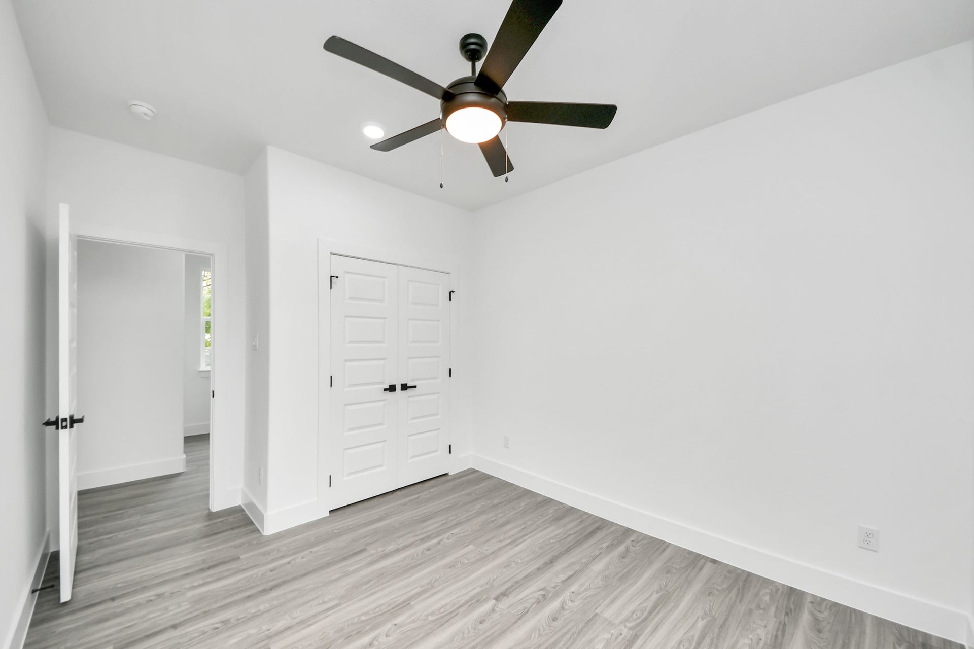 6707 Knox Street, Houston, TX 77091 Bright and airy room featuring sleek wood flooring, a modern ceiling fan, and ample closet space with double doors.