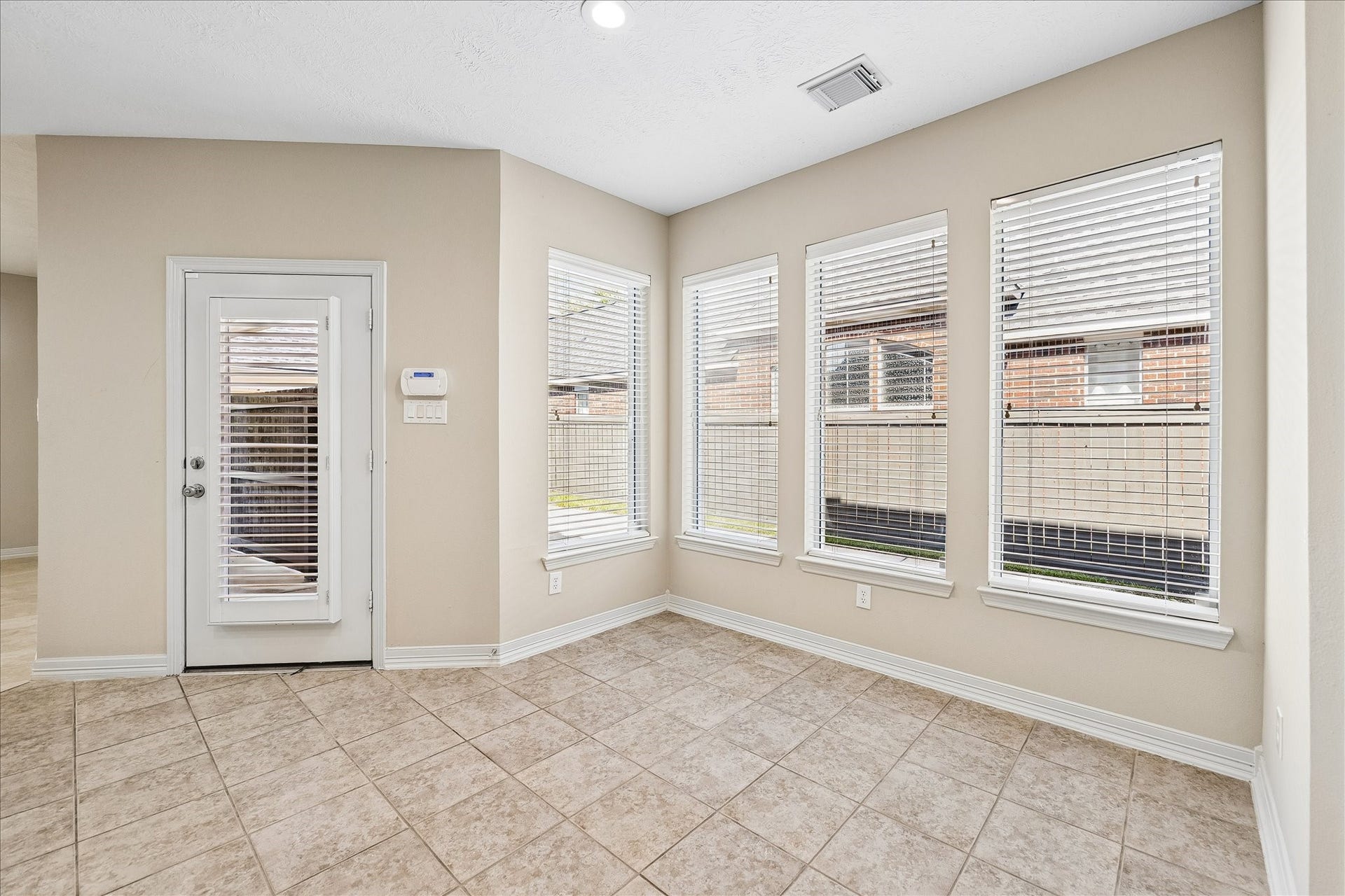 The breakfast area sits adjacent to the kitchen and offers ample seating for extra guests. Light-filled through many windows, it also opens to the patio and backyard.
