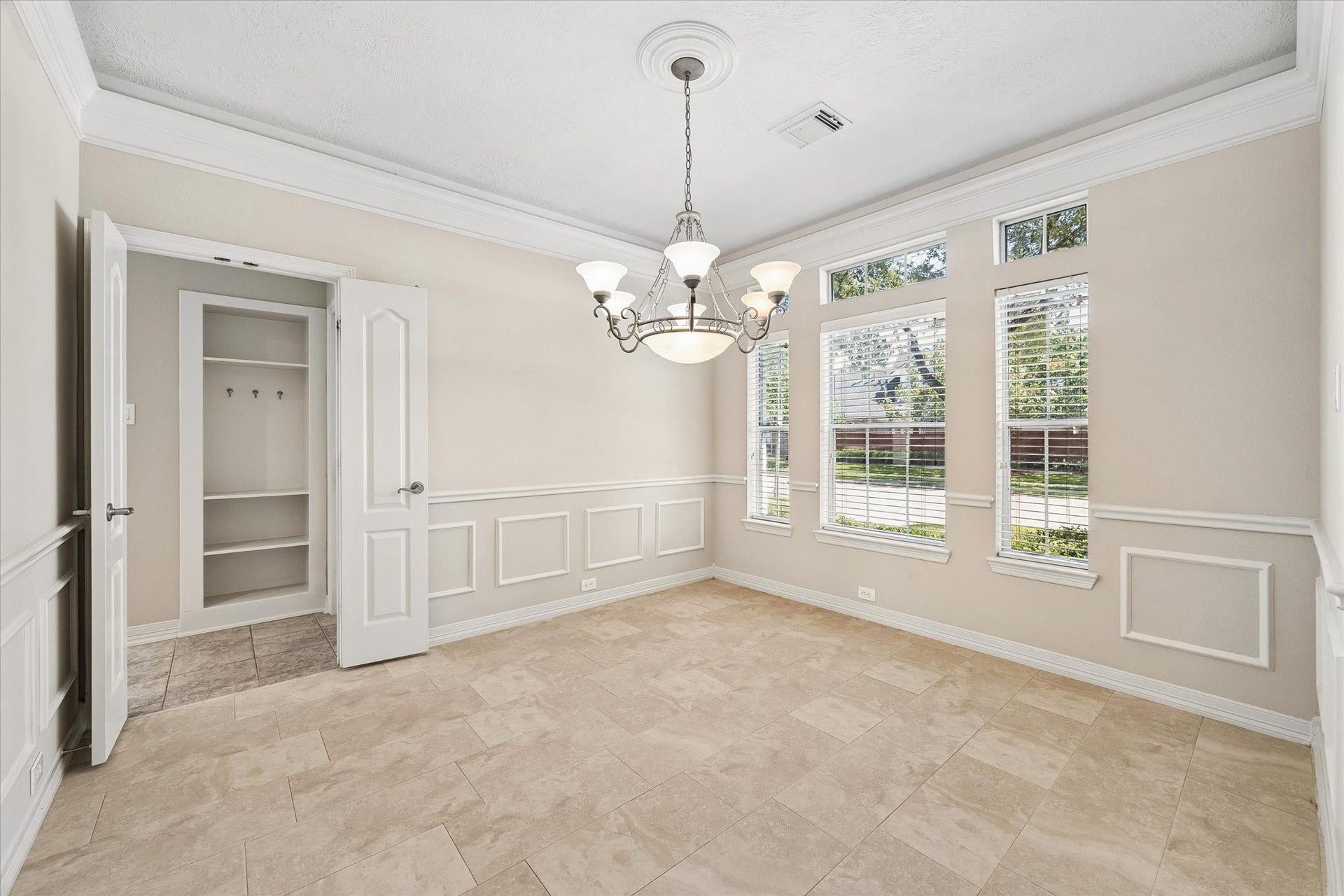 The dining room has a tray ceiling with crown molding, ample natural lighting, chair railing with picture frame molding and kitchen access.