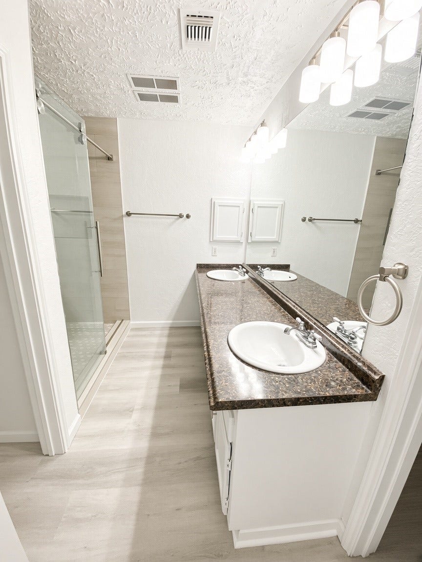 Master bathroom with double sinks and walk-in shower
