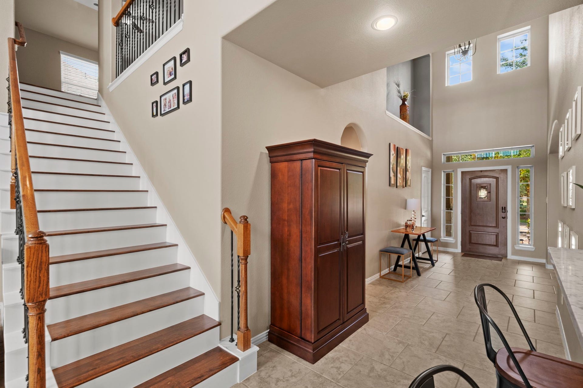 19519 Arbor Lodge Drive, Cypress, TX 77433 This welcoming entryway features high ceilings and abundant natural light. The space includes a wooden staircase with iron accents.The front door is flanked by sidelights, enhancing the airy feel of the foyer.
