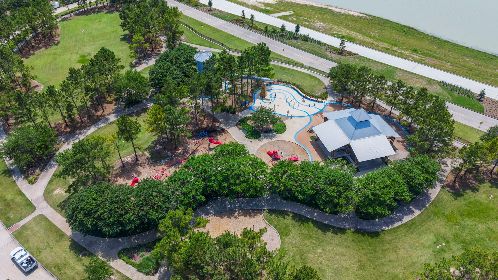 19519 Arbor Lodge Drive, Cypress, TX 77433 This is the lovely scenic park in front of the home with lush greenery, a winding pathway, & a vibrant playground area.