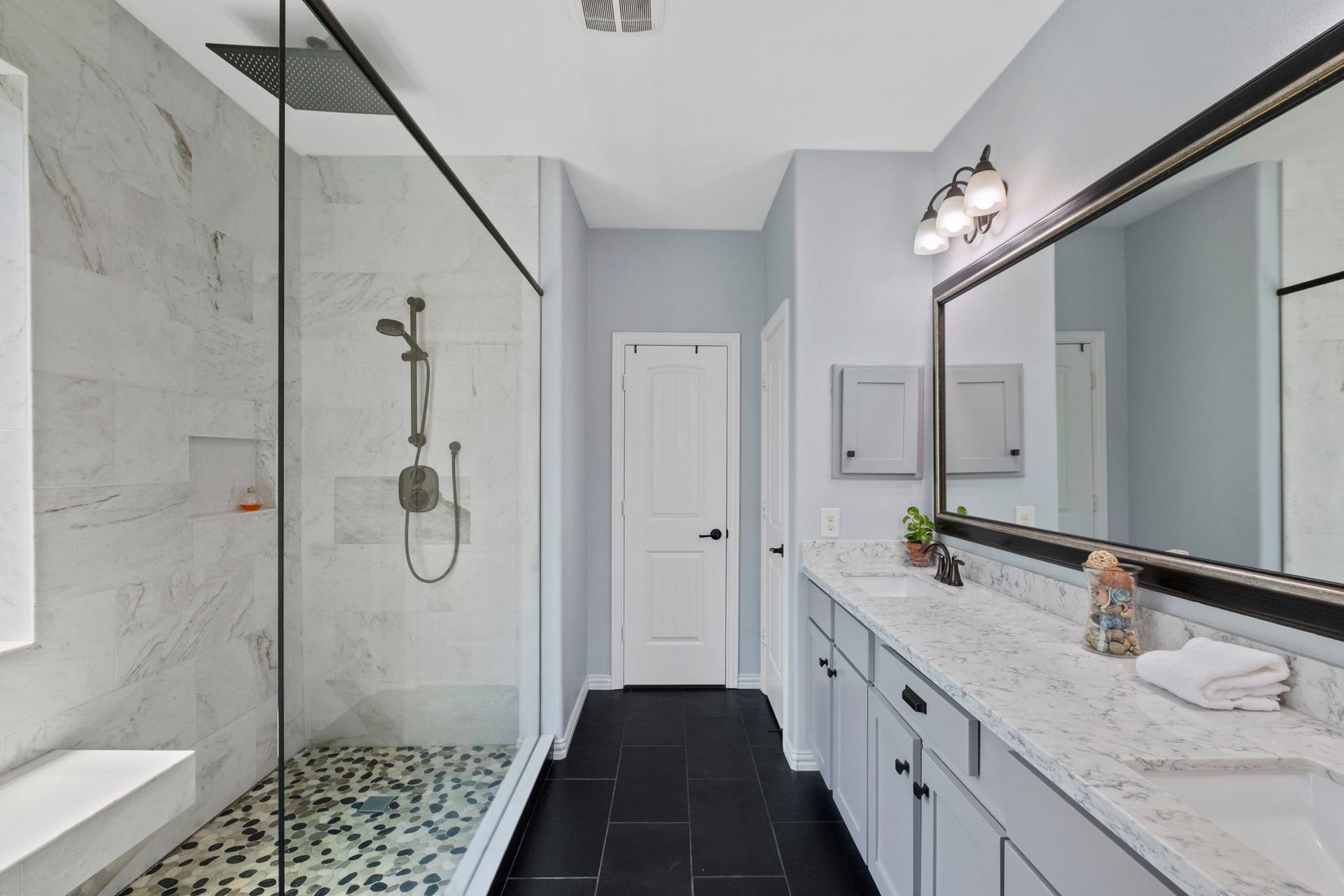 19519 Arbor Lodge Drive, Cypress, TX 77433 This bathroom features a sleek design with a large glass-enclosed shower, marble-look walls,