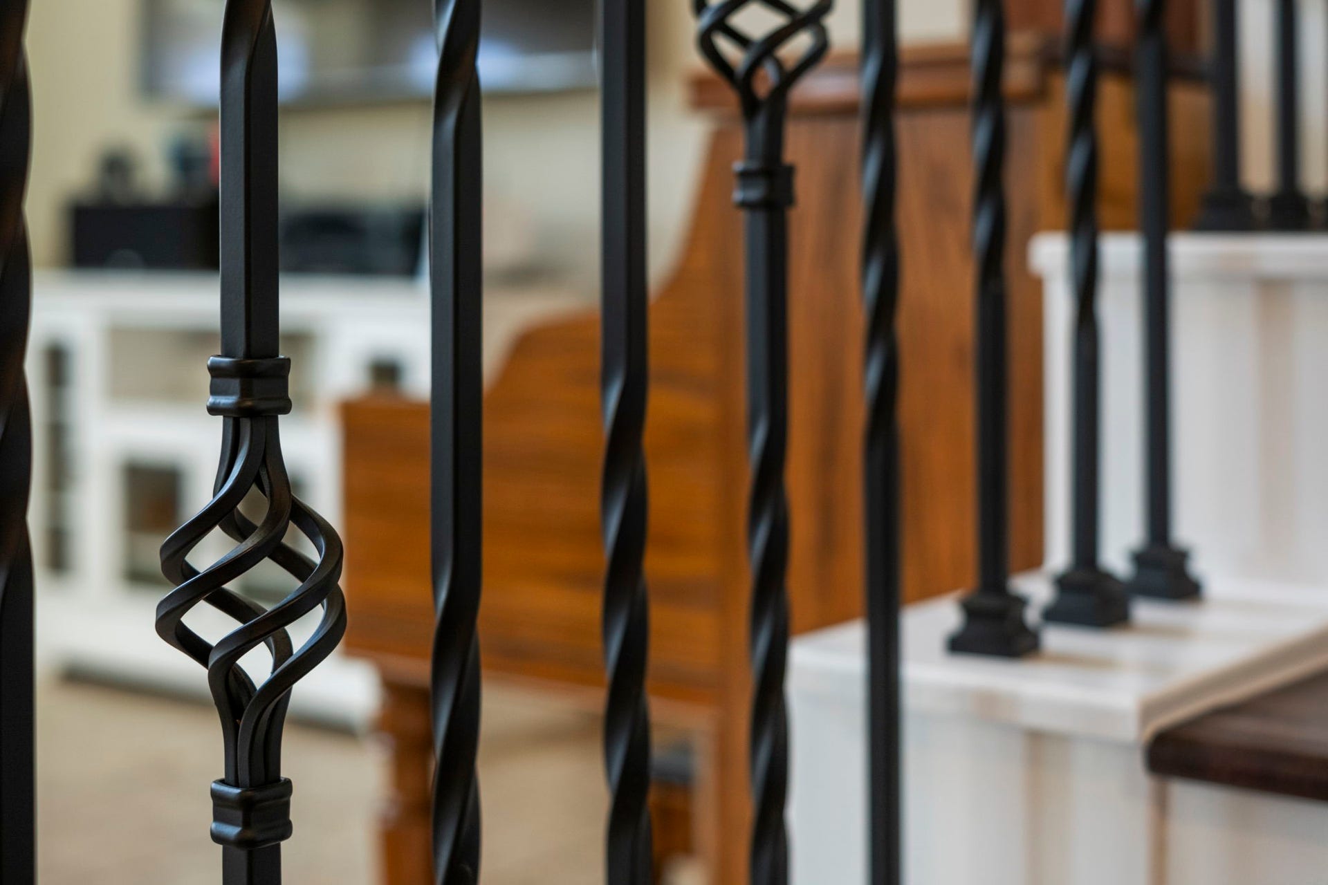 19519 Arbor Lodge Drive, Cypress, TX 77433 The staircase offers elegant black wrought iron balusters featuring intricate designs, complemented by wooden steps.
