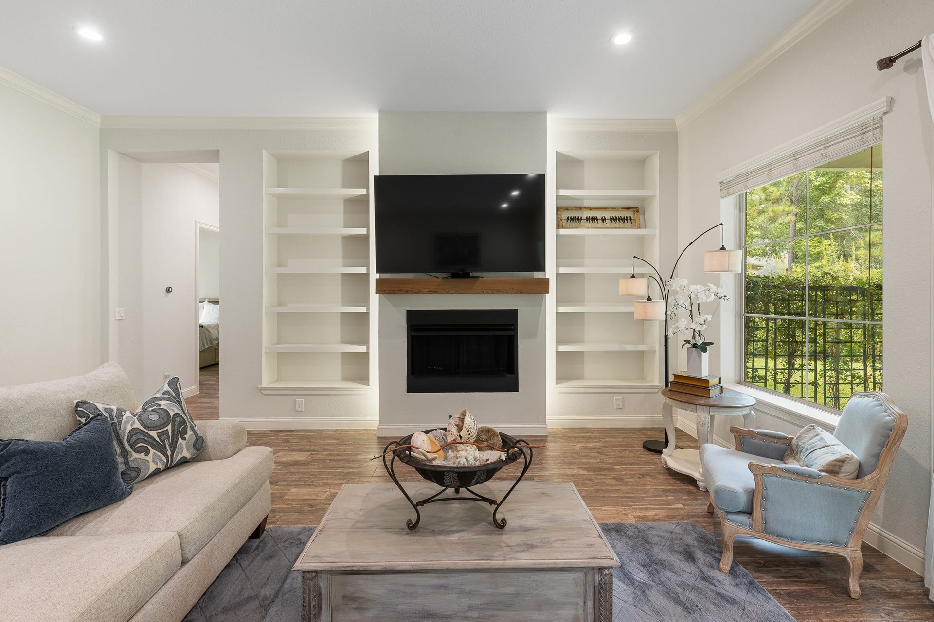 12134 S Tara Plantation Drive, Tomball, TX 77375 Living room with gas fireplace and built-ins with back lit lighting.