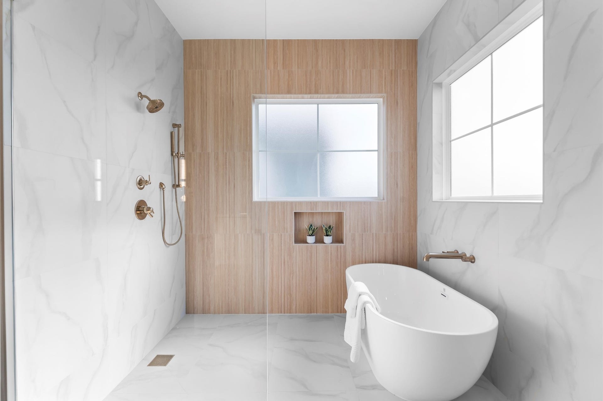 Primary bath features curbless shower and separate soaking tub.