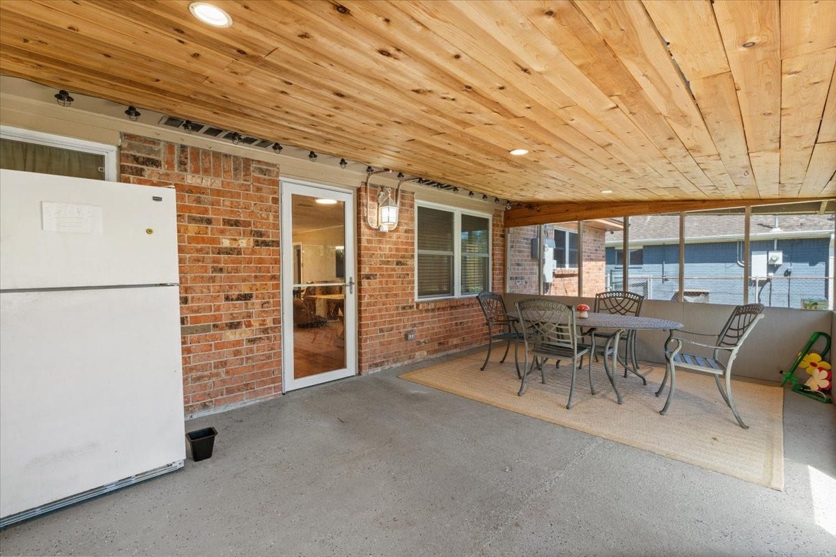 1209 E Brown Lane, Deer Park, TX 77536 Spacious covered patio with a charming wood ceiling, perfect for outdoor dining and relaxation. Outdoor refrigerator included
