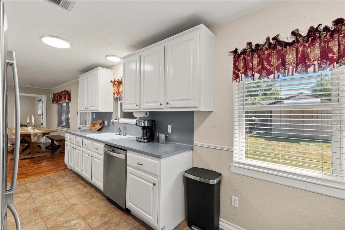 1209 E Brown Lane, Deer Park, TX 77536 Bright and inviting kitchen featuring ample cabinetry, and a cozy dining area with natural light streaming through large windows. This space could be your dining room and your living space could be just living space