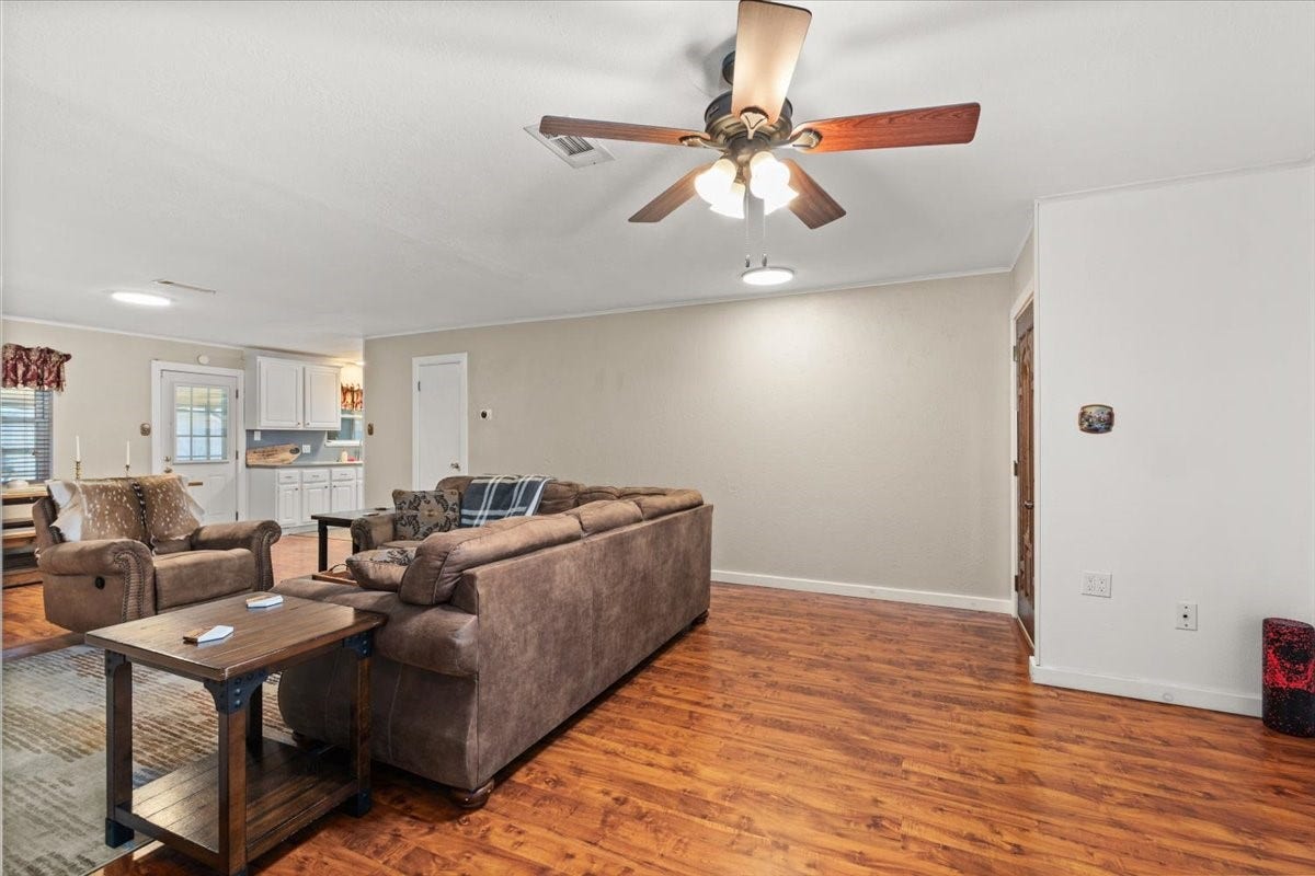 1209 E Brown Lane, Deer Park, TX 77536 Spacious living area with warm wood flooring, new ceiling fan, open concept with seamless flow into the kitchen