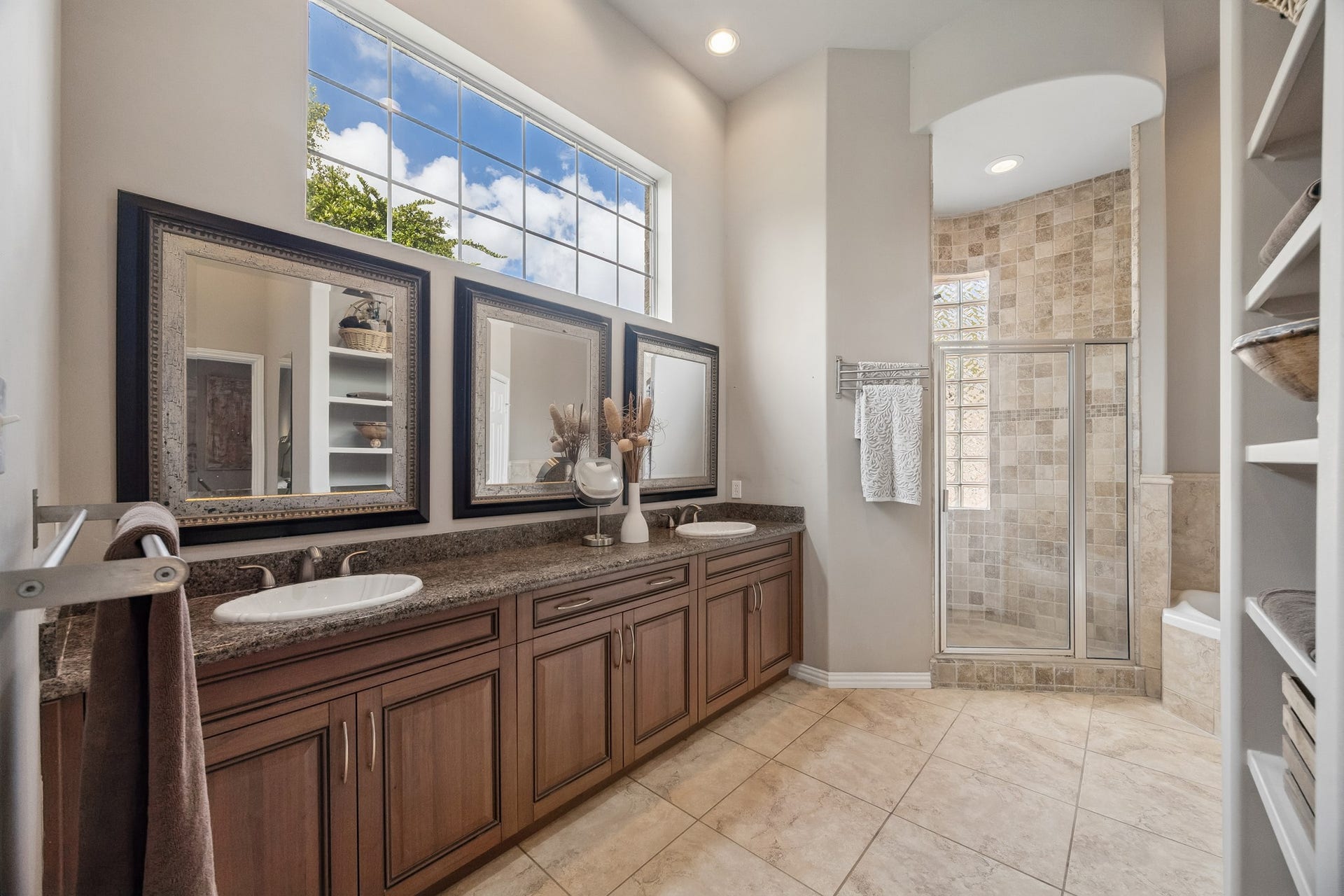 1319 Brazoswood Place, Richmond, TX 77406 Primary bathroom features dual sinks, his/hers closets, separate stand-alone shower and jetted tub. Notice the rich cabinetry, natural light and neutral color scheme.