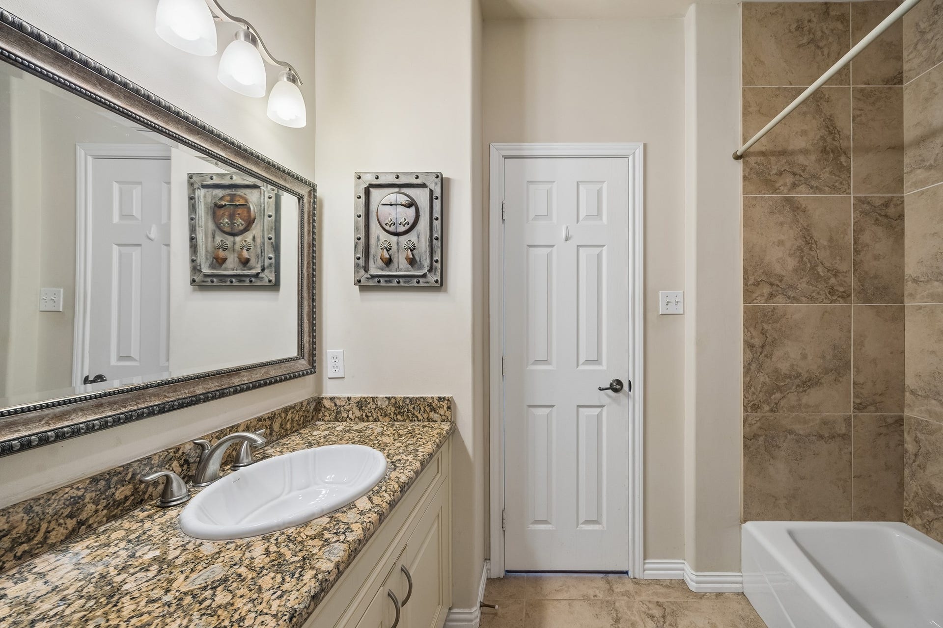 1319 Brazoswood Place, Richmond, TX 77406 Secondary bathroom with framed mirrors and granite countertops. Neutral color scheme throughout with brushed nickel hardware.