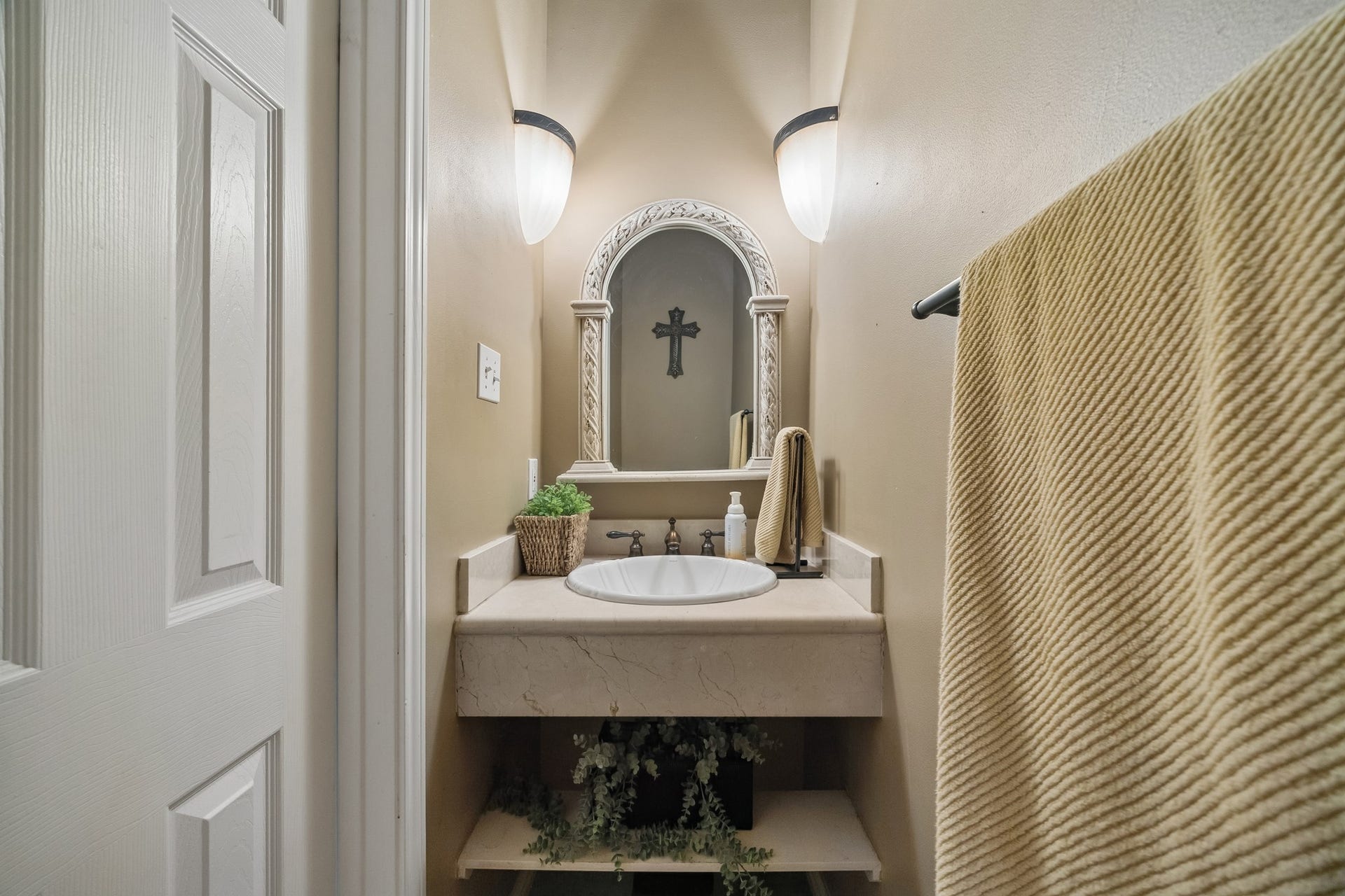 1319 Brazoswood Place, Richmond, TX 77406 Quaint powder bathroom with stone countertops, an arched mirror and conveniently located off the main living areas.