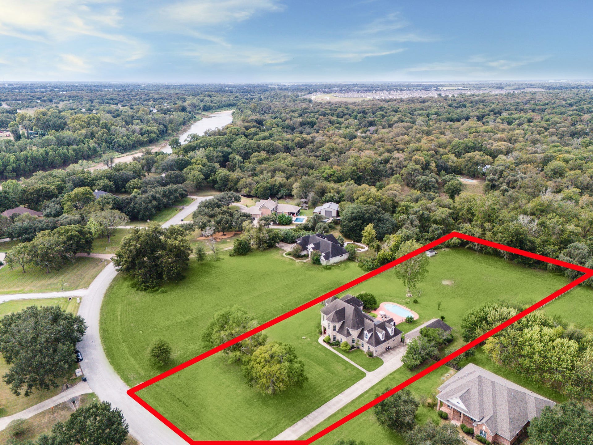 1319 Brazoswood Place, Richmond, TX 77406 Aerial view showcasing an impressive estate set on expansive, fenced acreage with mature trees and lush greenery. 2.12 acres set on a no-thru traffic street.