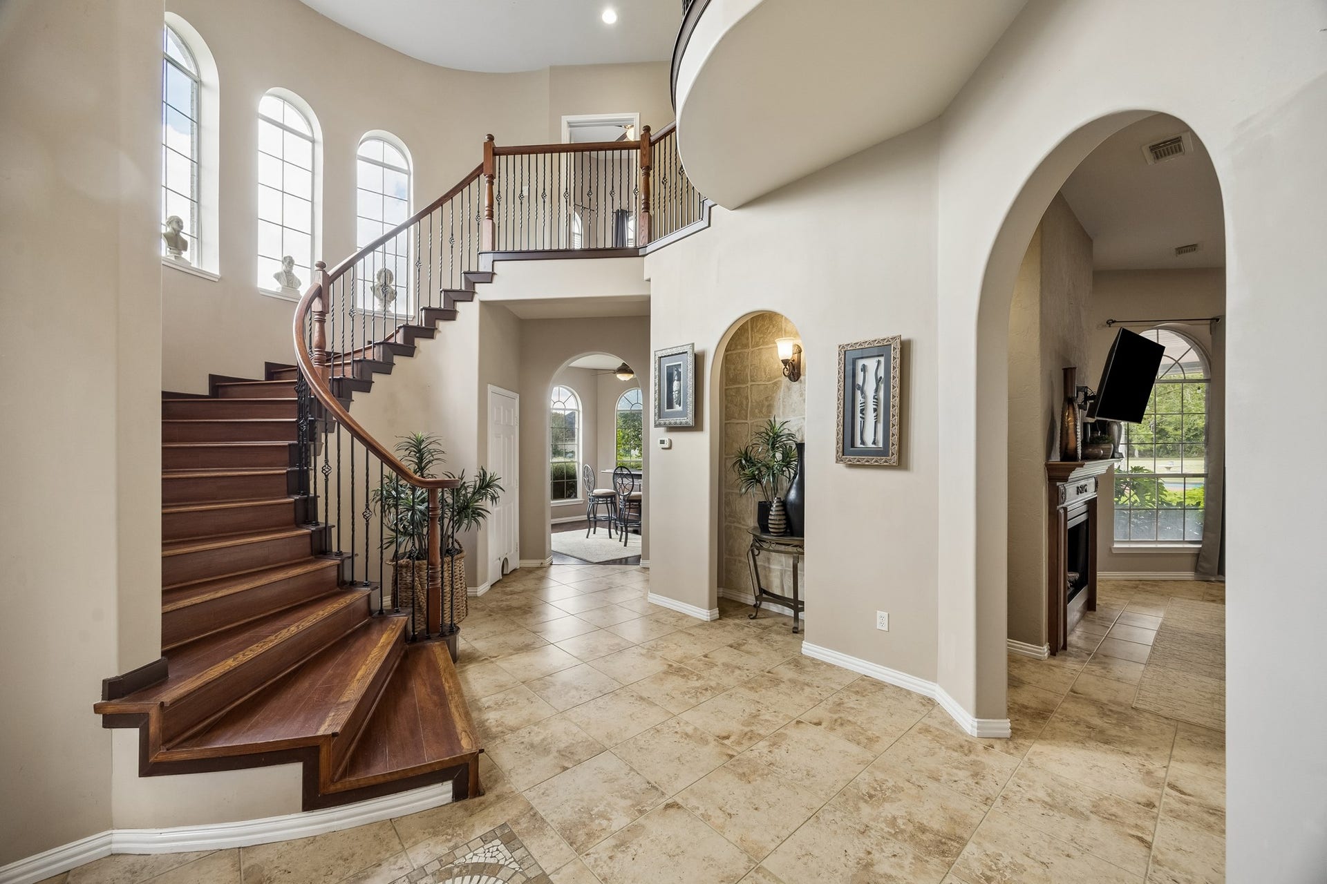 1319 Brazoswood Place, Richmond, TX 77406 Grand and welcoming entry. Natural light fills this impressive entry, highlighting the rich wood staircase, soaring ceilings, and elegant architectural details.