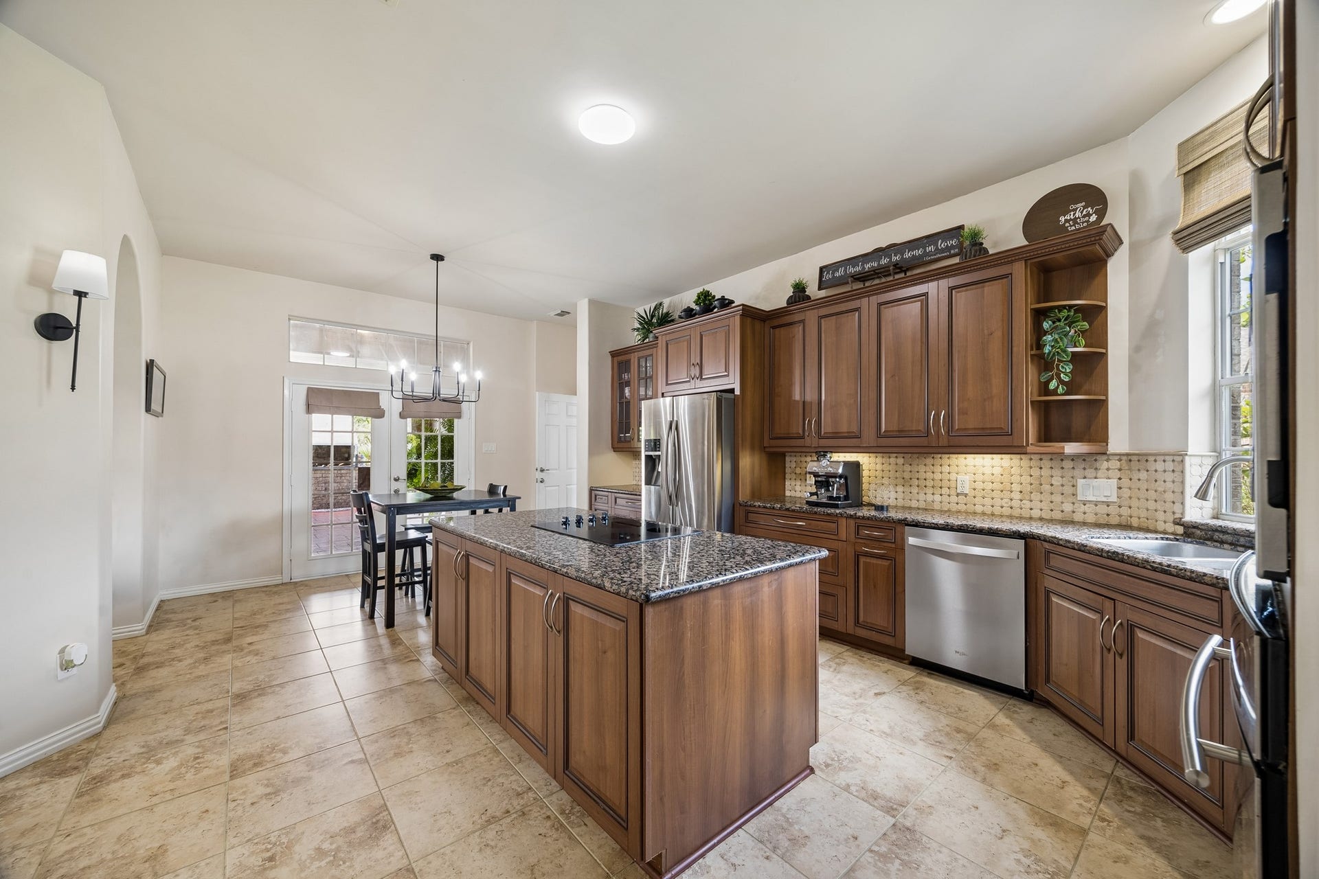 1319 Brazoswood Place, Richmond, TX 77406 A spacious chef-inspired kitchen showcases rich custom cabinetry, granite countertops, stainless-steel appliances, and an oversized island with cooktop.