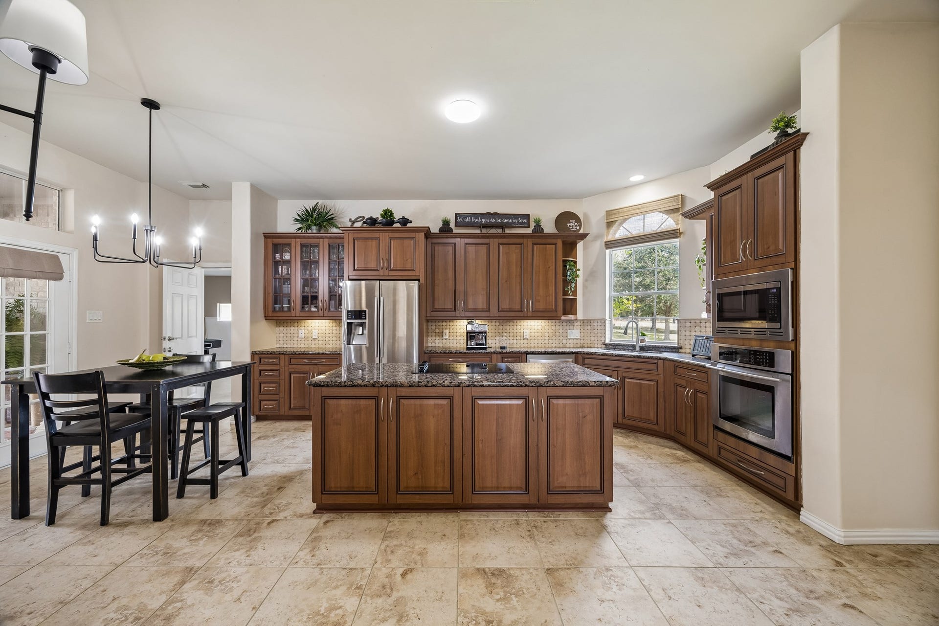 1319 Brazoswood Place, Richmond, TX 77406 A spacious chef-inspired kitchen showcases rich custom cabinetry, granite countertops, stainless-steel appliances, and an oversized center island. Notice the picturesque window just beyond the sink with front of home views.