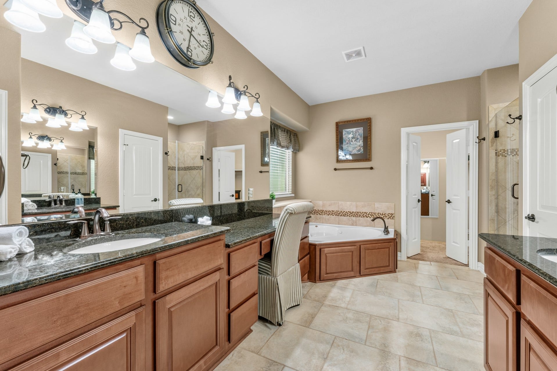 3 Blue Wildflower Pl, The Woodlands, TX 77354 Your spa-like ensuite features separate sinks and vanity areas, a jetted tub, separate walk-in shower, and linen closet for extra storage.
