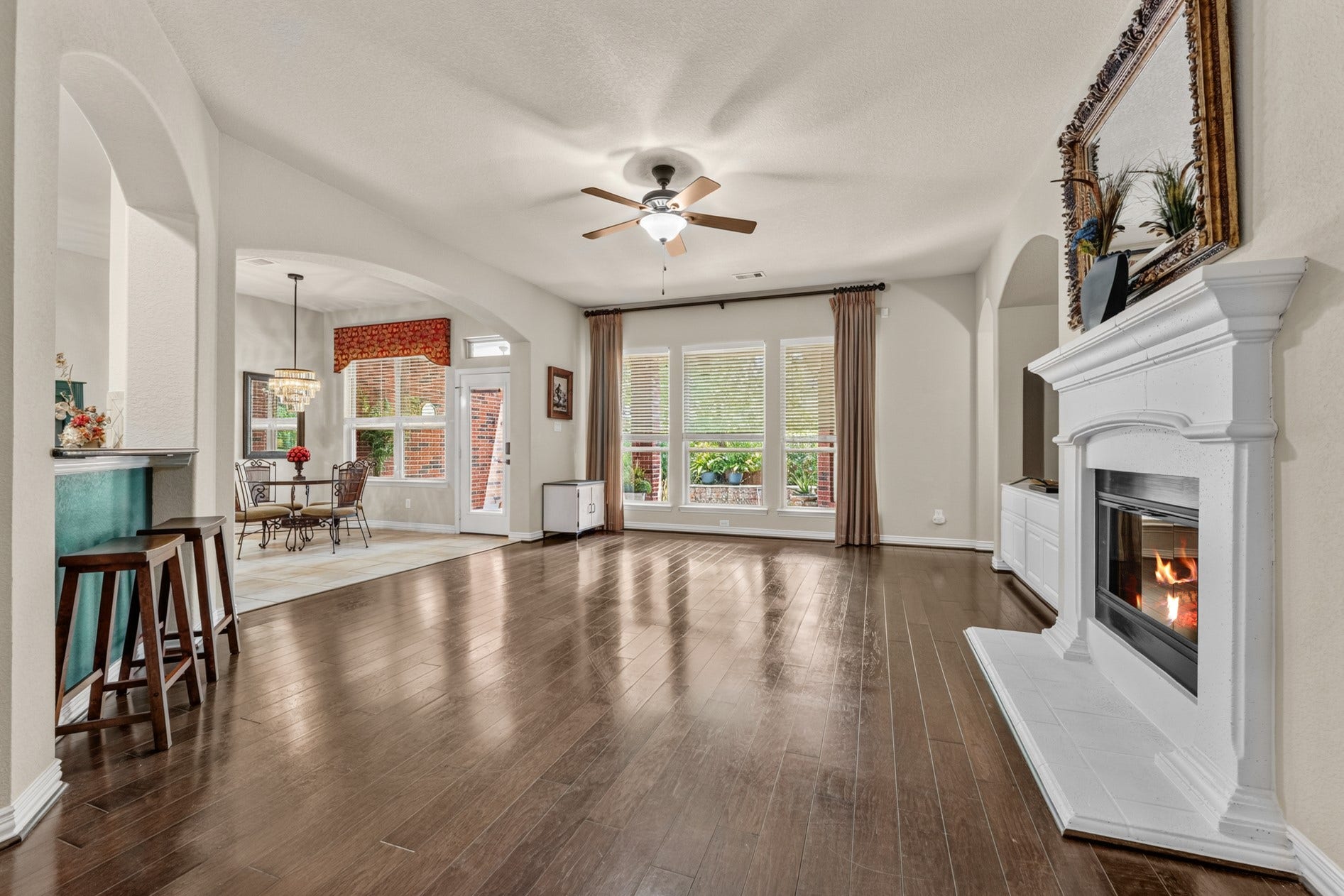 3 Blue Wildflower Pl, The Woodlands, TX 77354 Back downstairs - This spacious living room is a great gathering spot! Three large windows provide a view of the sparkling pool!