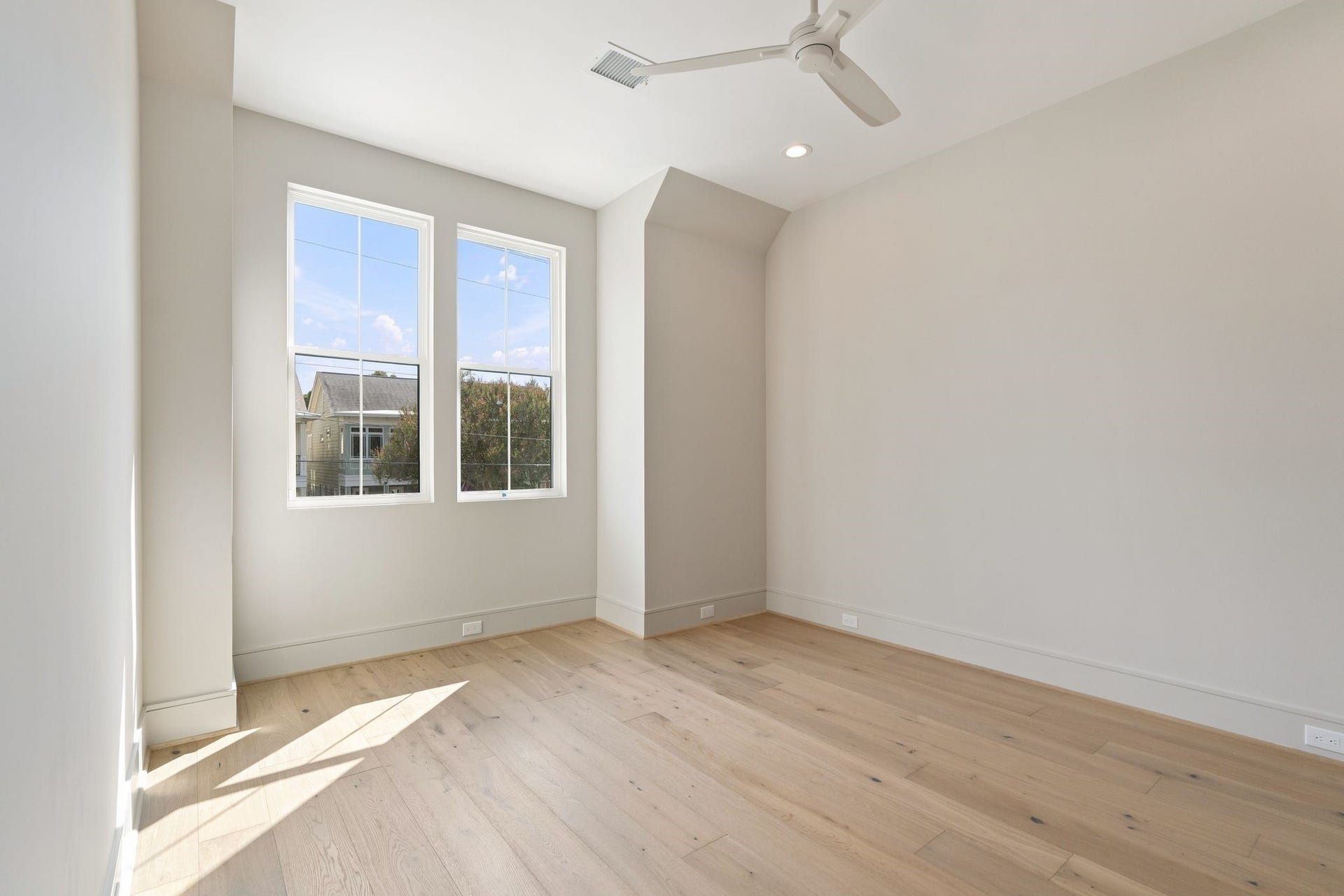 711 E 12th Street, Houston, TX 77008 Light-filled bedroom 4 with hardwood floors, white Minka and natural light.