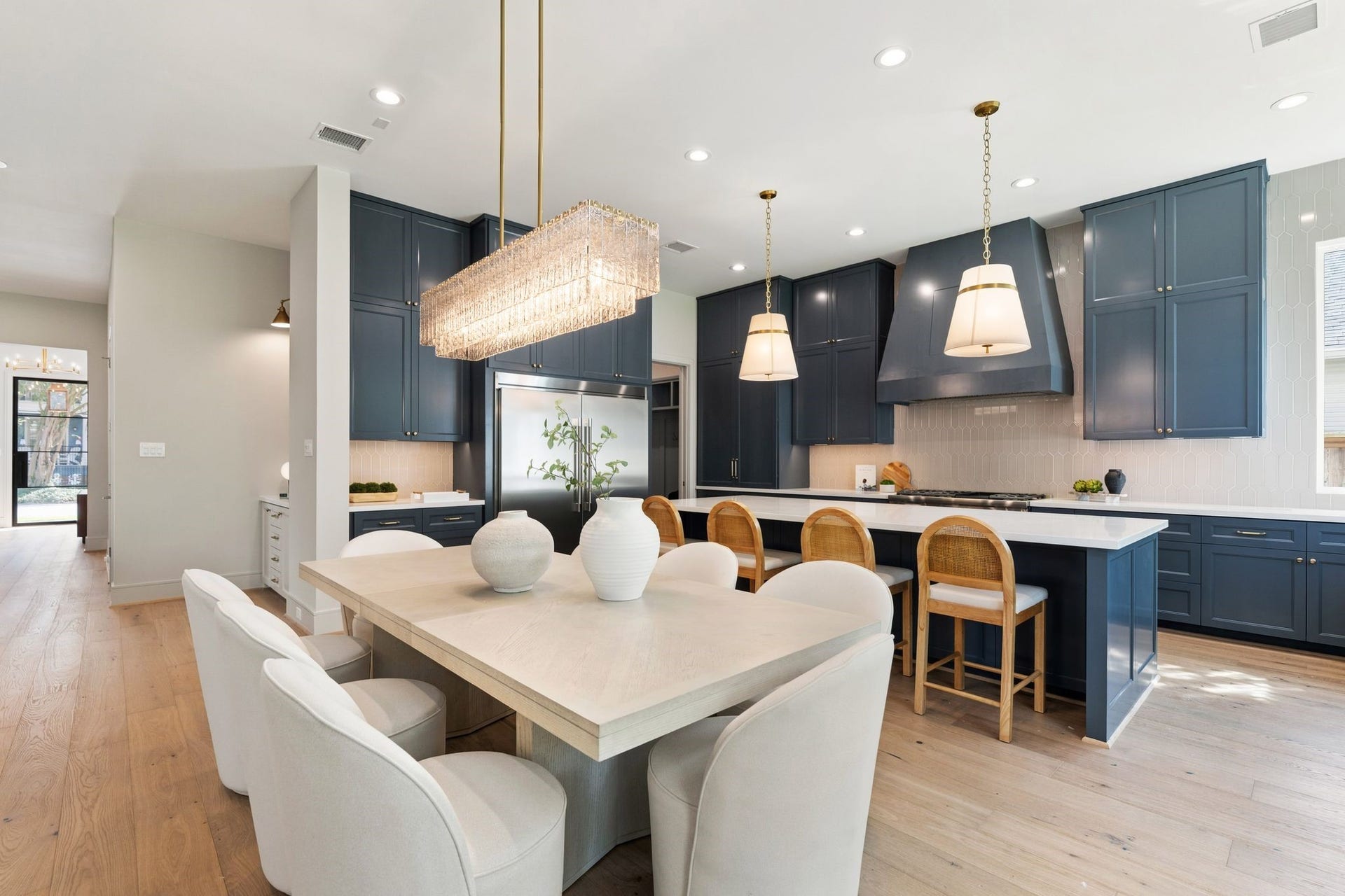711 E 12th Street, Houston, TX 77008 From daily breakfasts at the island to dinner parties beneath the Z-Lite Glacier chandelier, this connected dining and kitchen space makes gathering easy.