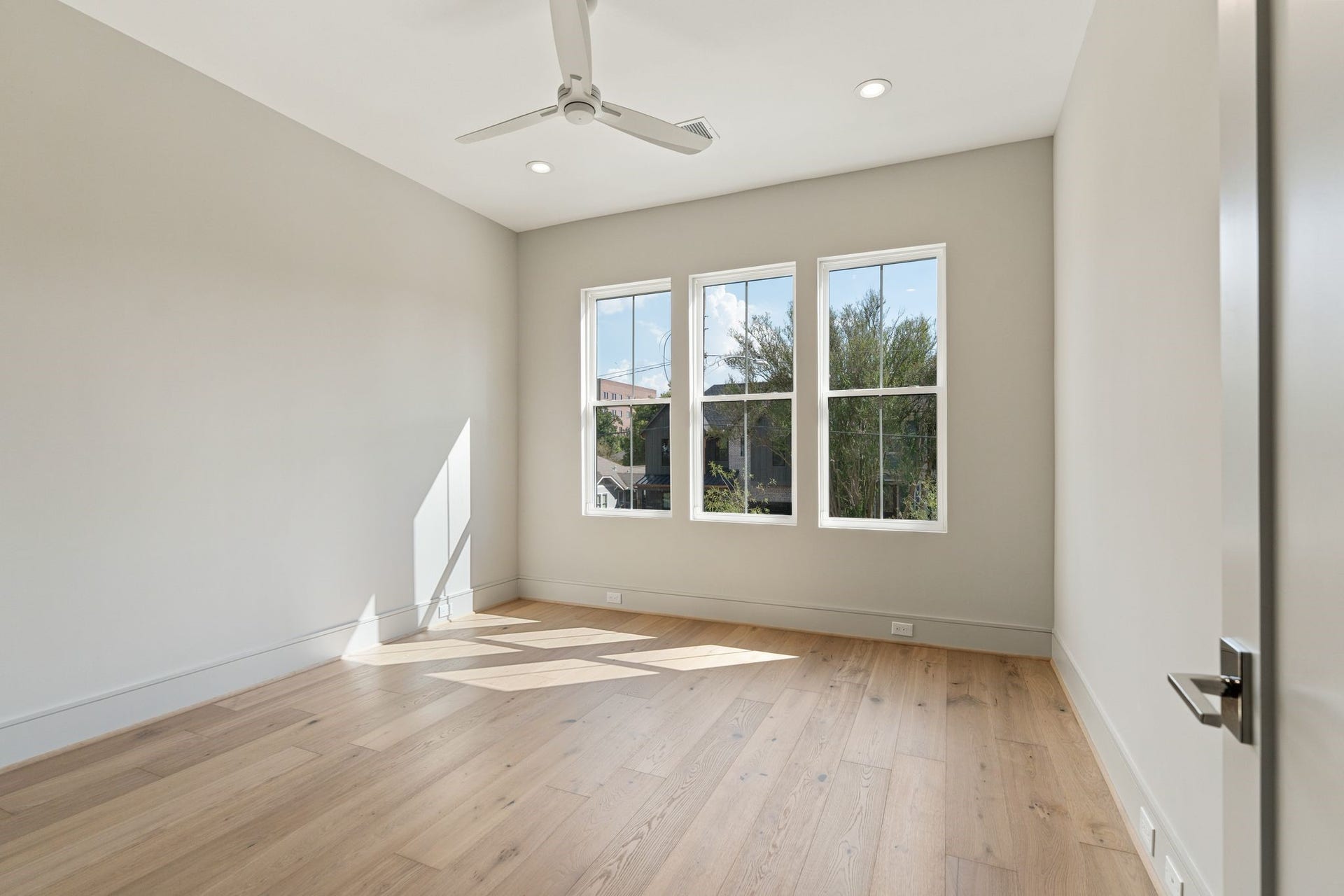 711 E 12th Street, Houston, TX 77008 Light-filled bedroom 4 with hardwood floors, white Minka and natural light.