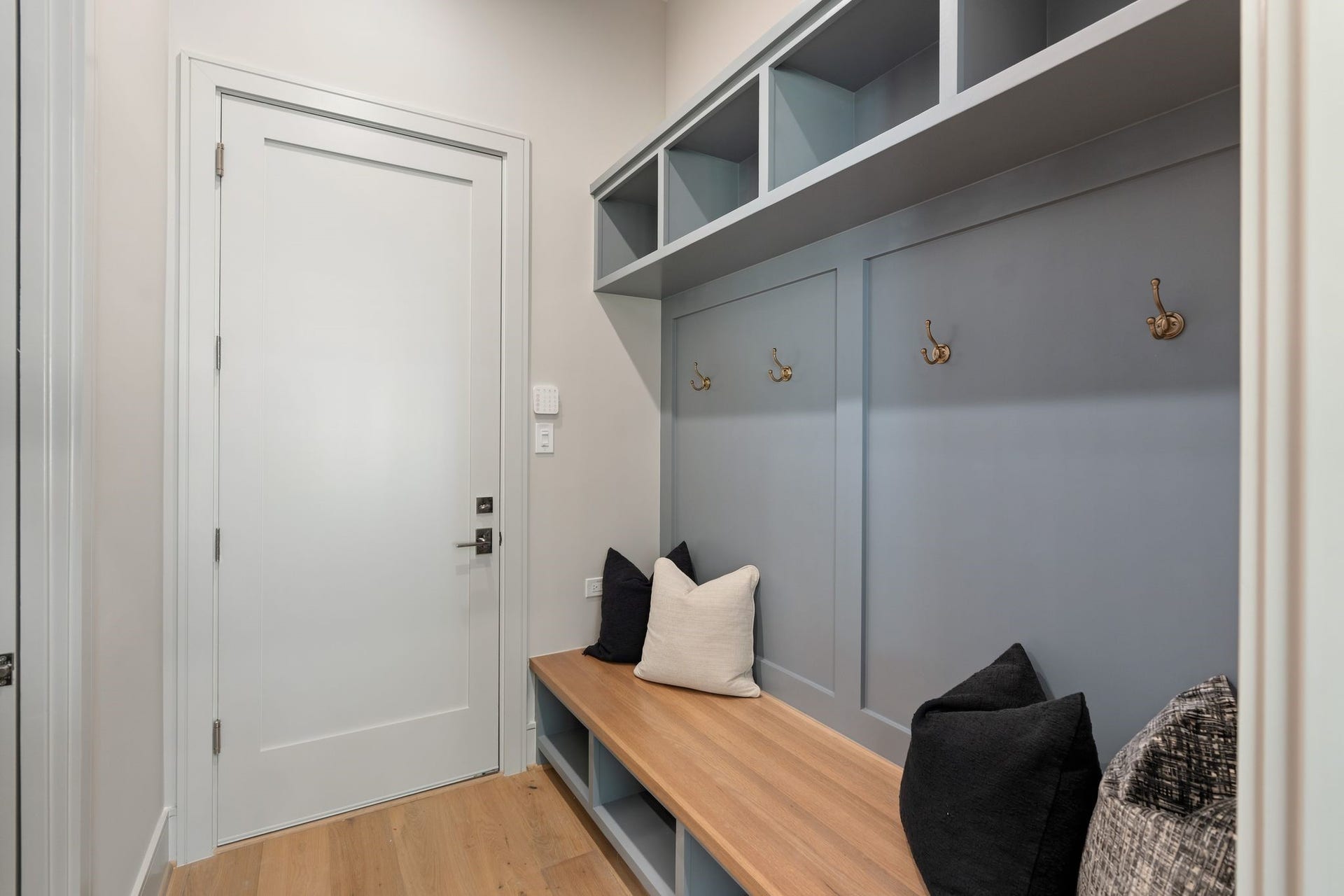 711 E 12th Street, Houston, TX 77008 The mudroom pairs built-ins in Sherwin-Williams Cadet with a warm stained wood bench. Upper and lower cubbies and convenient hooks keep everyday essentials organized and ready for the next outing.