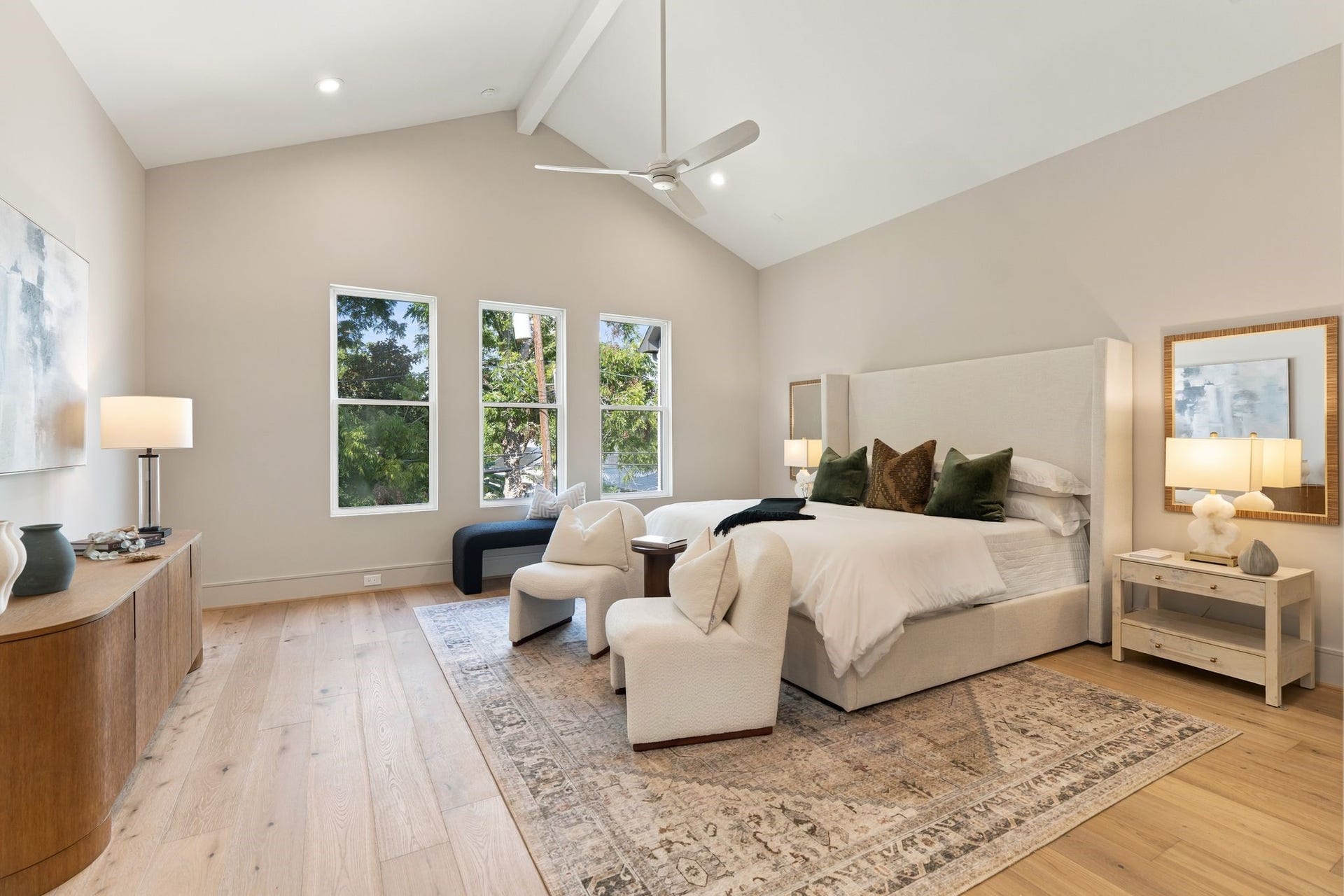 711 E 12th Street, Houston, TX 77008 A vaulted ceiling adds height and character to the spacious primary bedroom, while generous windows frame views of the backyard and mature tree. F