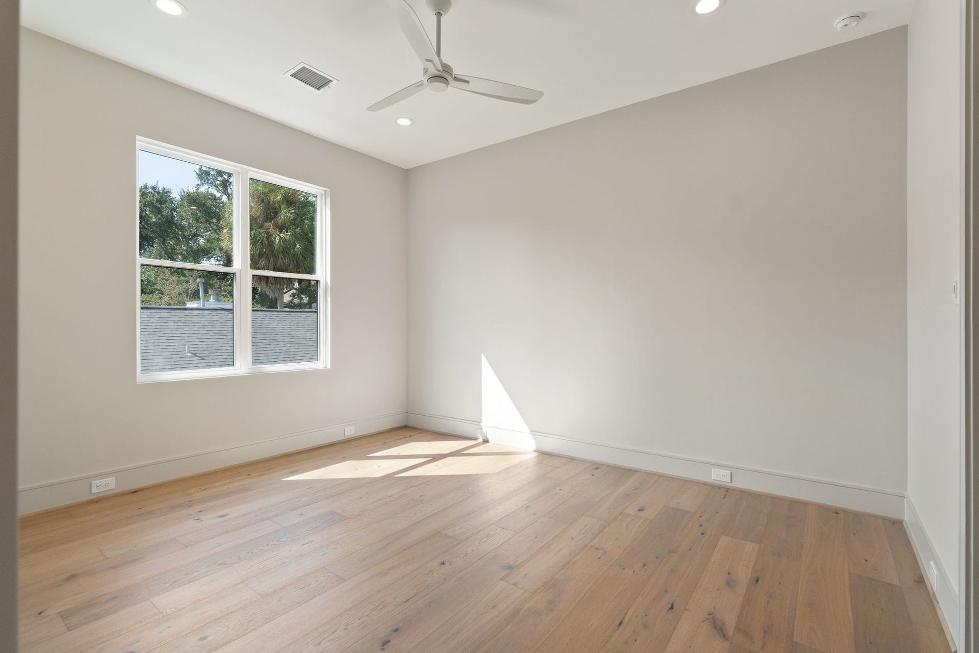 711 E 12th Street, Houston, TX 77008 Bright bedroom 2 with warm hardwood flooring, ceiling fan and generous natural light.