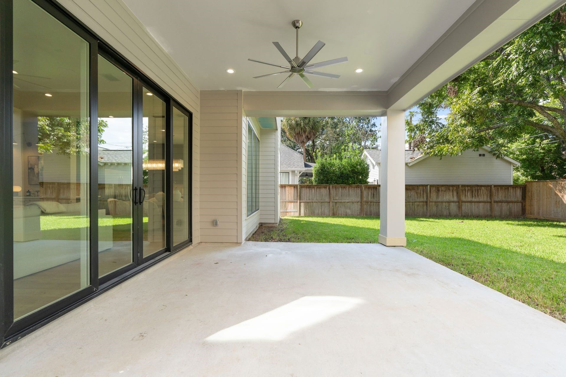 711 E 12th Street, Houston, TX 77008 Sliding glass doors keep the spaces connected, while a ceiling fan and gas hookup add everyday convenience. Beyond, the expansive lawn and mature corner tree create a beautiful backdrop with welcome shade.