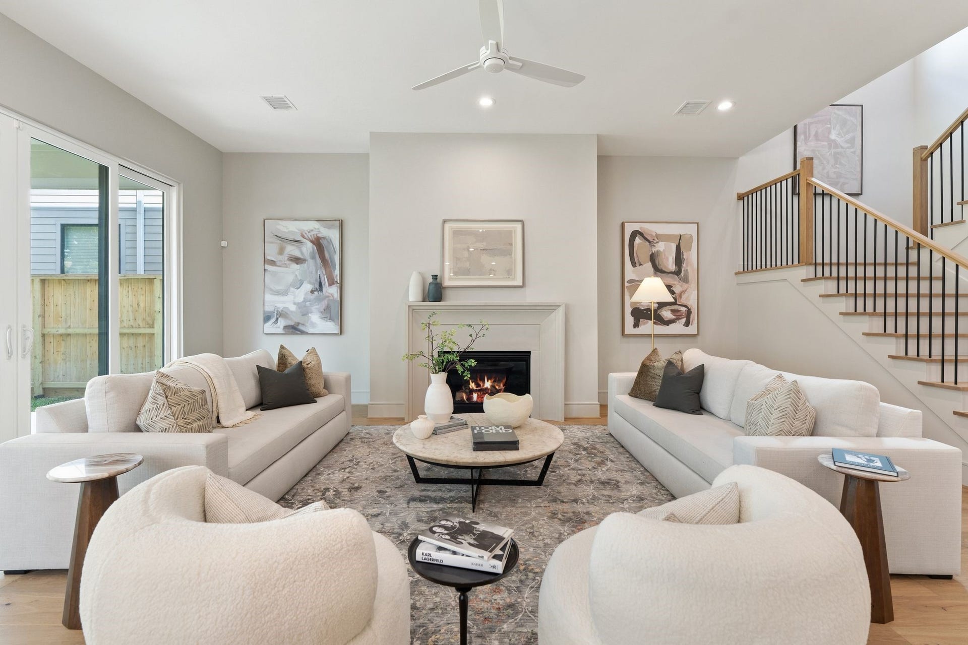 711 E 12th Street, Houston, TX 77008 A cast stone fireplace anchors the space, while warm hardwood floors connect the open living areas. Expansive windows and sliding glass doors bring the backyard into view and open to the generous covered porch.