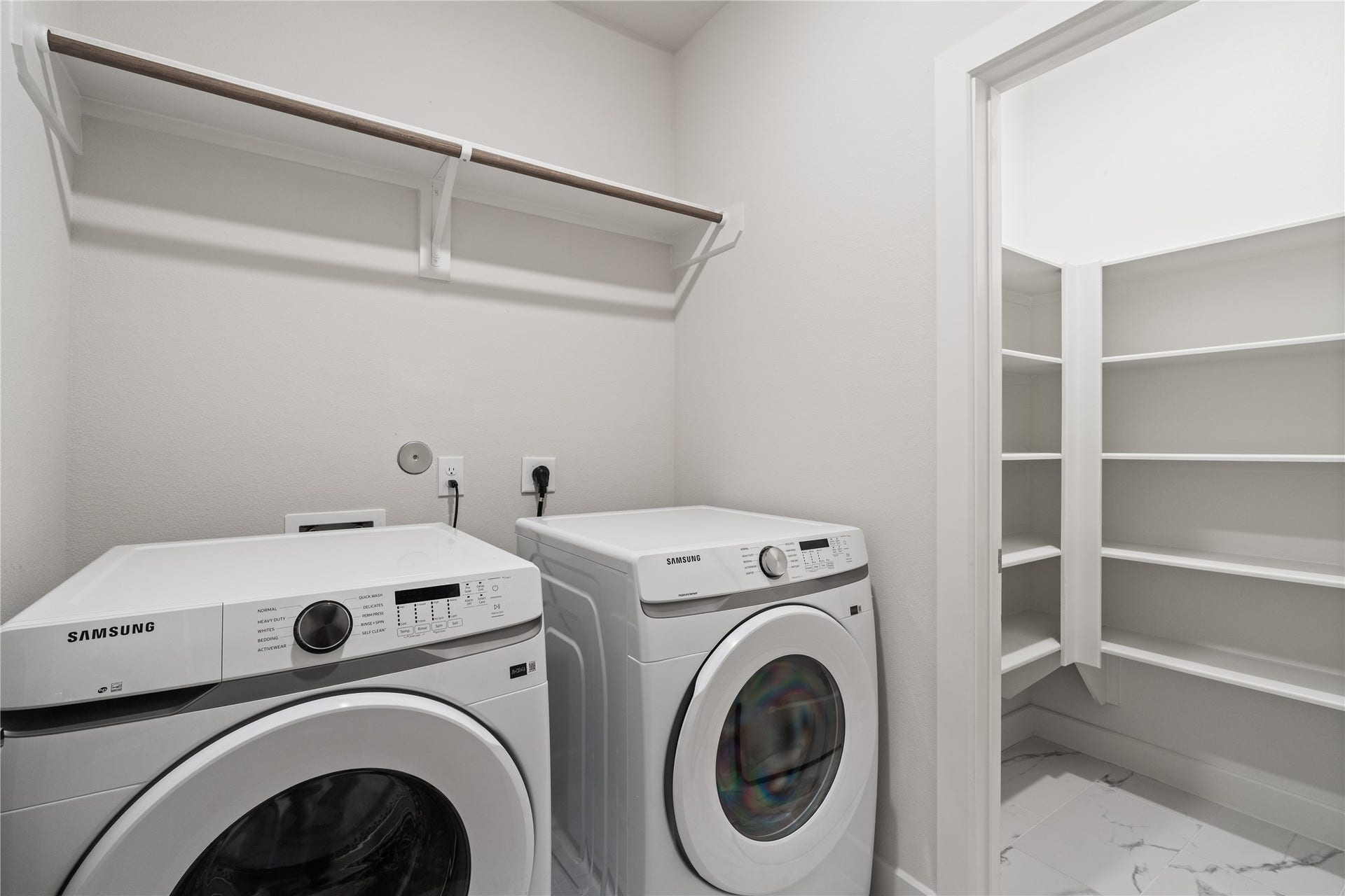 6509 Rena Street, Houston, TX 77092 Spacious laundry room with side by side setup, upper hanging space, and a dedicated storage closet with built in shelving for added organization.