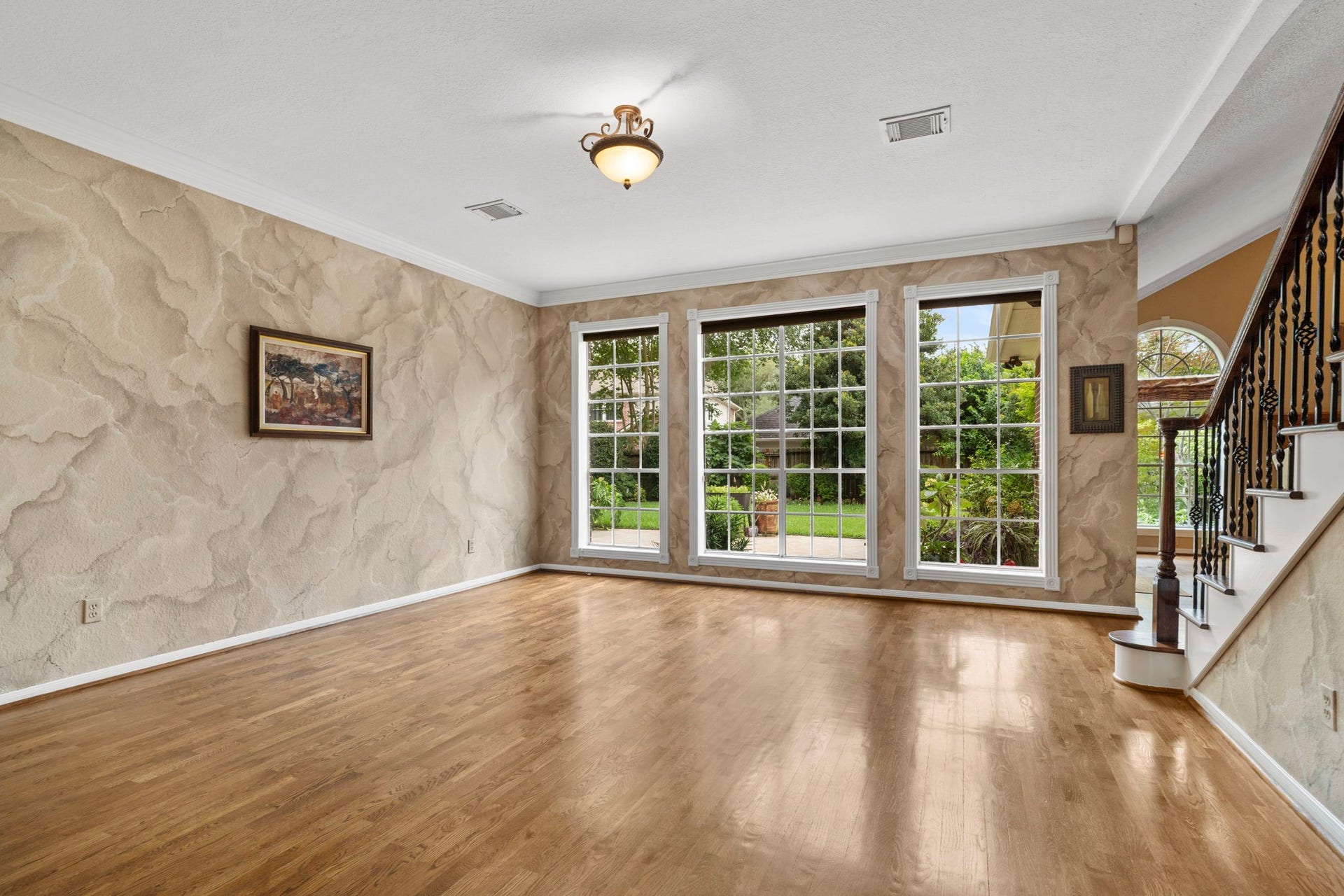23 Saint Simons Court, Sugar Land, TX 77479 The spacious living room features a wall of windows that overlook the patio.