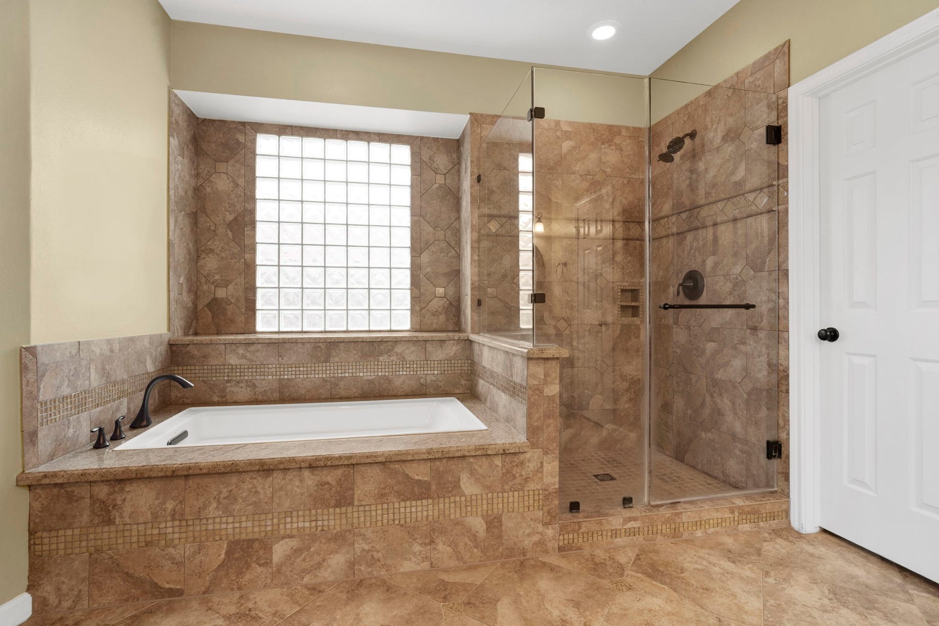 23 Saint Simons Court, Sugar Land, TX 77479 The en suite owners bath combines a deep soaking tub with a seamless glass shower, offering a serene, spa-inspired atmosphere.