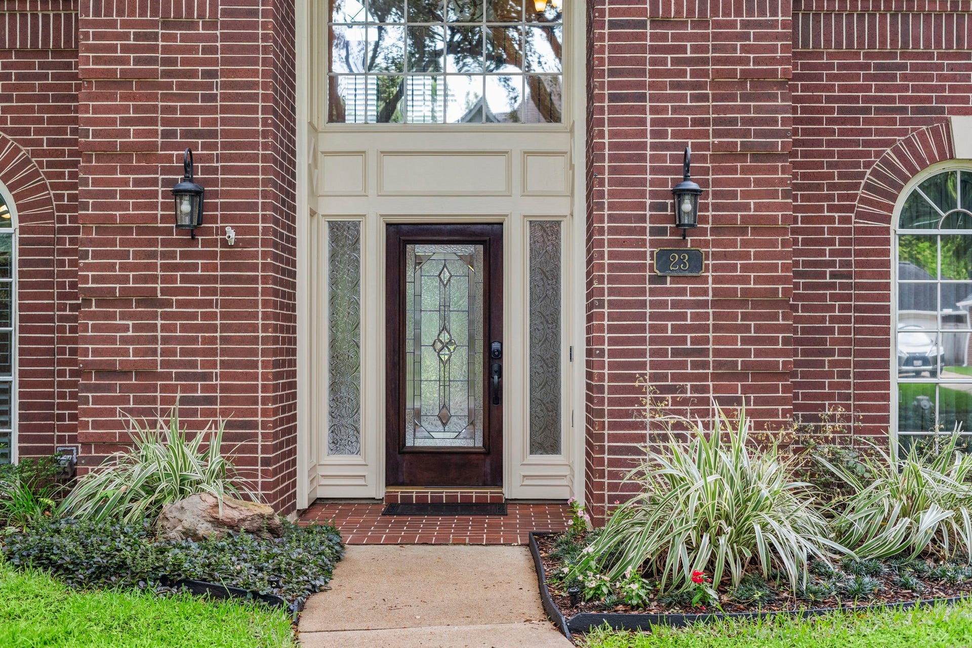 23 Saint Simons Court, Sugar Land, TX 77479 An inviting entry welcomes you through a solid wood front door with intricate leaded glass, framed by distinctive sidelights and topped by a tall arched window.