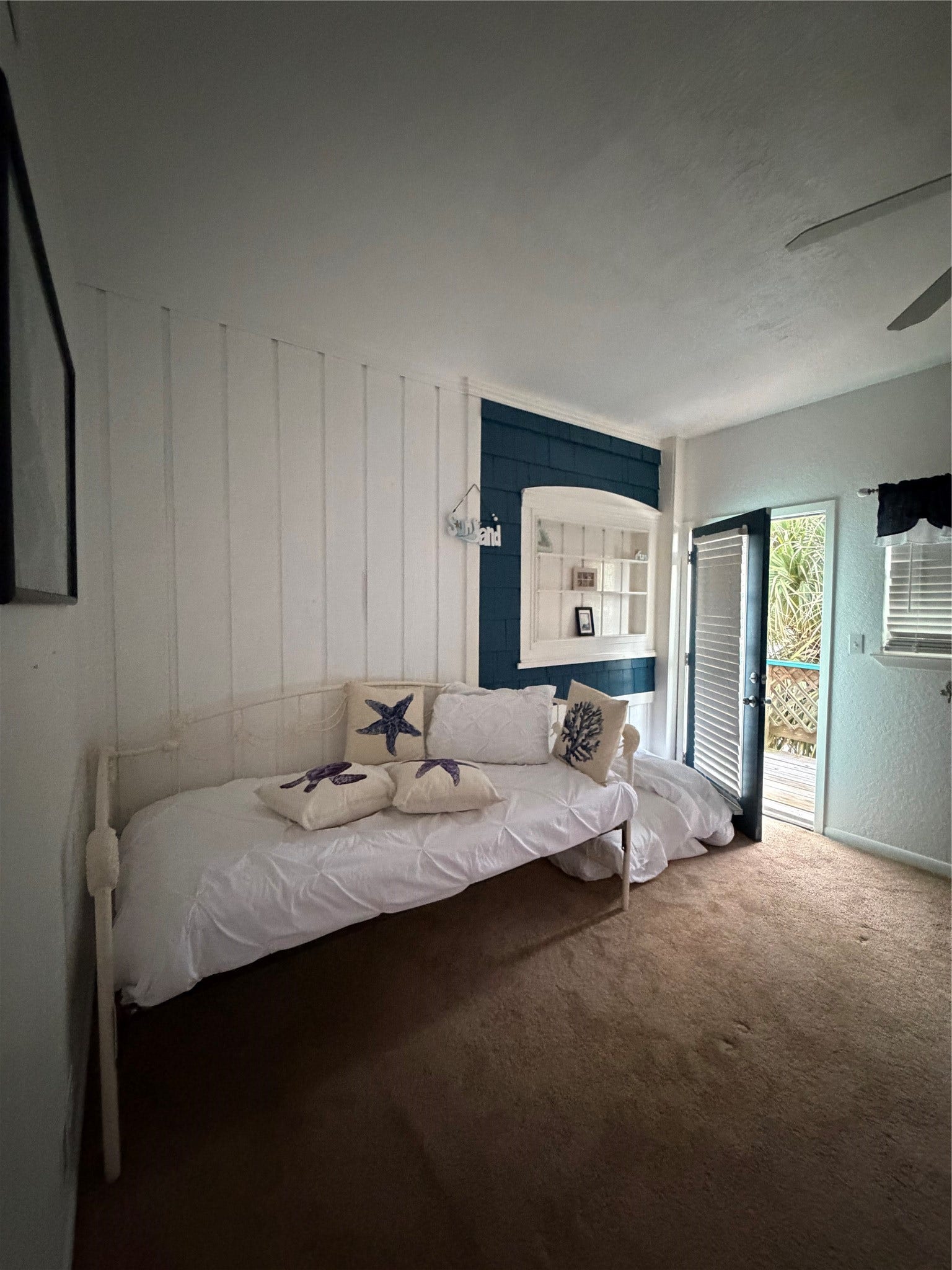 13002 Buccaneer Parkway, Freeport, TX 77541 Cozy daybed in the primary bedroom. A doorway that opens to an upper balcony with stunning bay views, perfect for sunset moments.