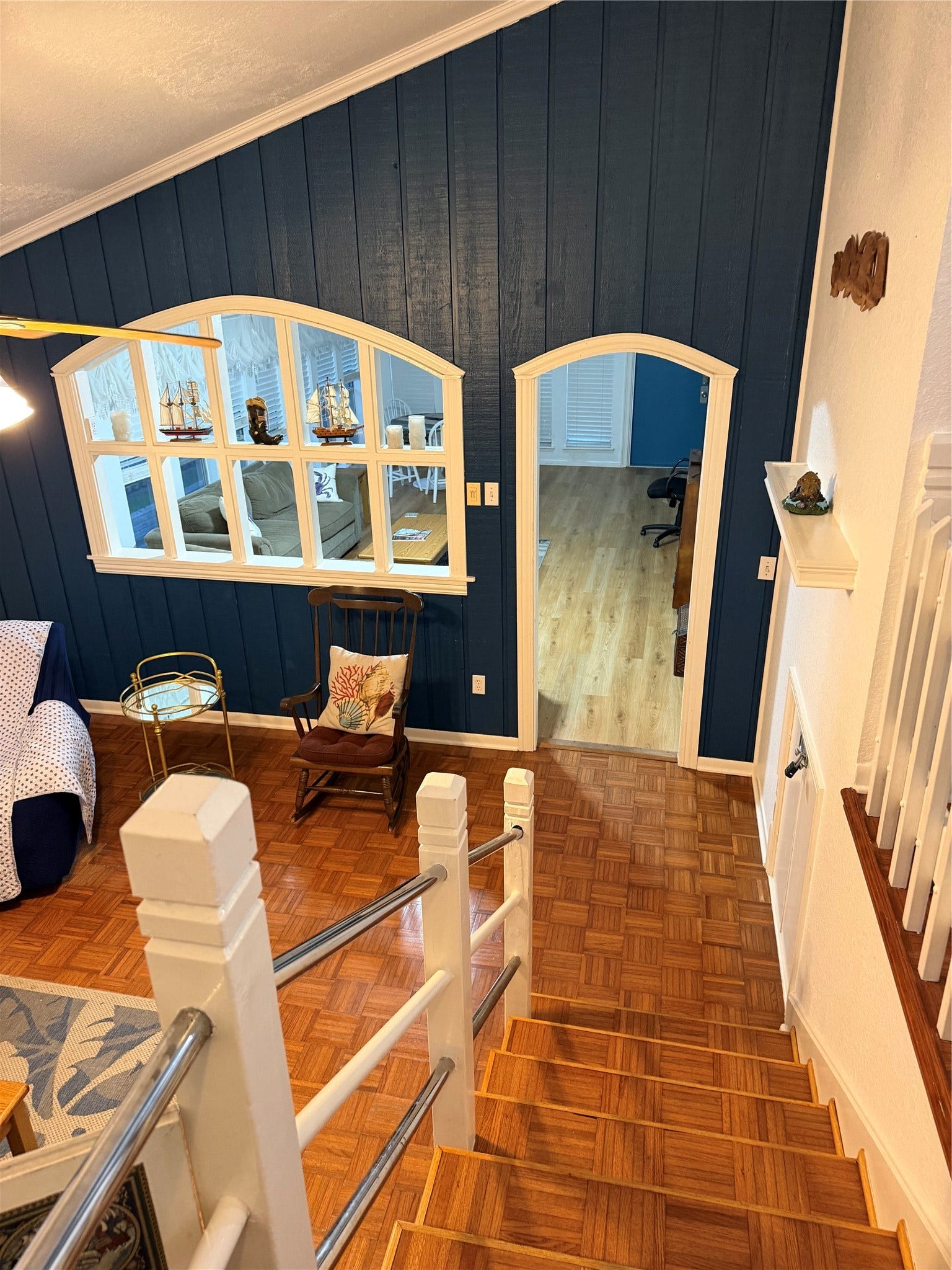 13002 Buccaneer Parkway, Freeport, TX 77541 Descend into a cozy den/library featuring warm wood flooring and rich blue walls, perfect for relaxation and study.